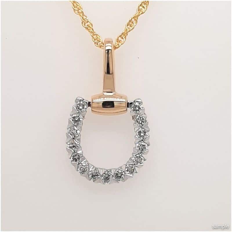 Gold necklace with a horse bit pendant, decorated with small white gems.