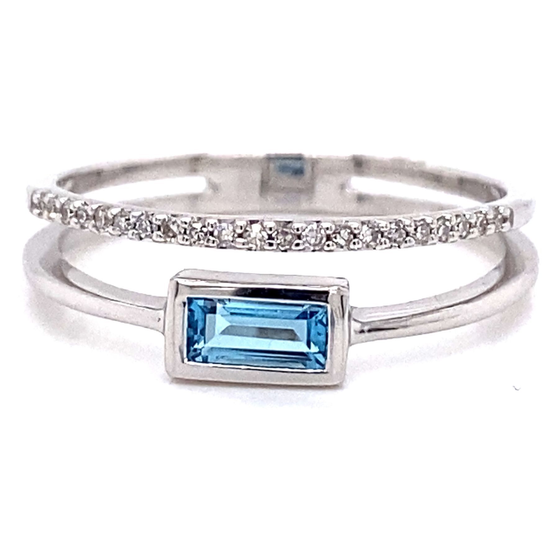 Silver ring with a blue rectangular gemstone and a band with small white gems.