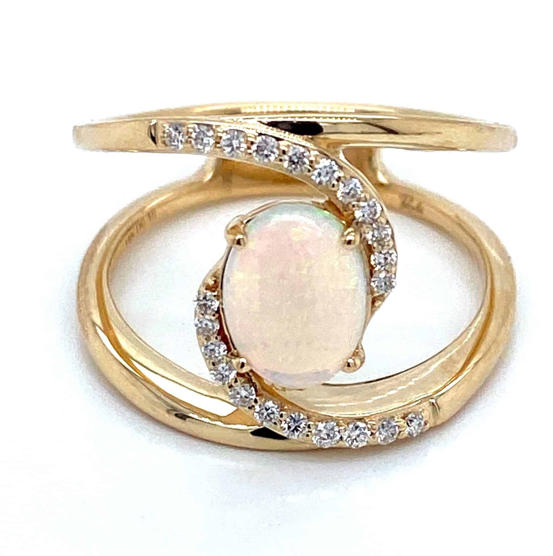 Gold ring with oval opal center stone, surrounded by a swirl of small diamonds.
