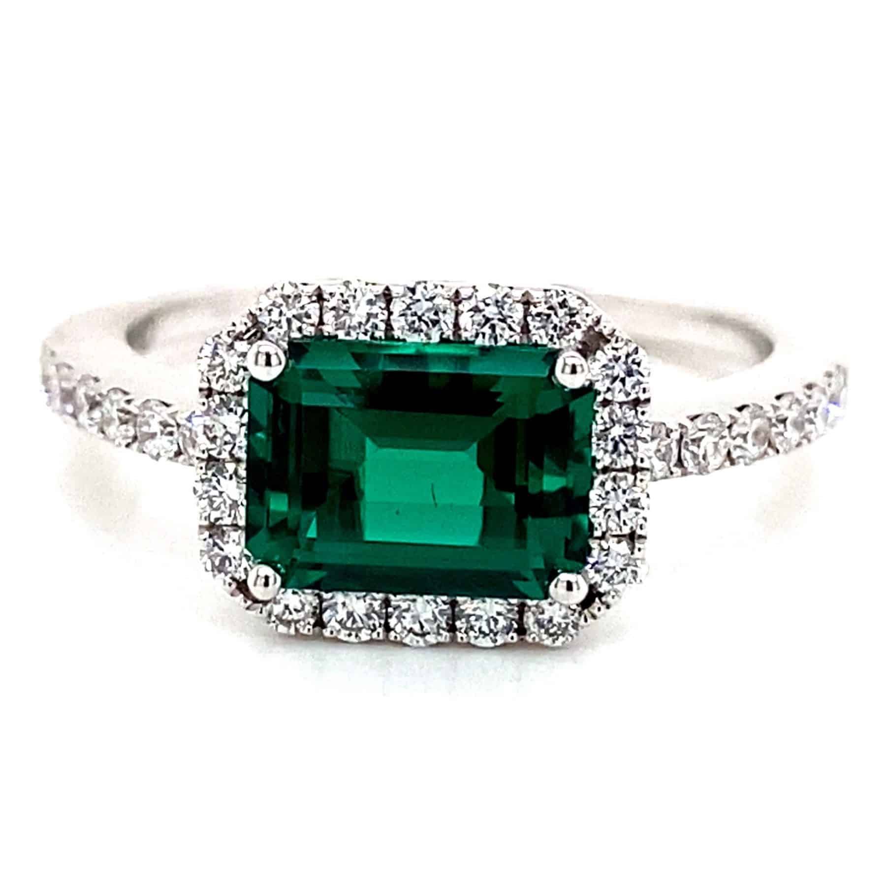 Emerald-cut emerald ring with a diamond halo and diamond-studded band.