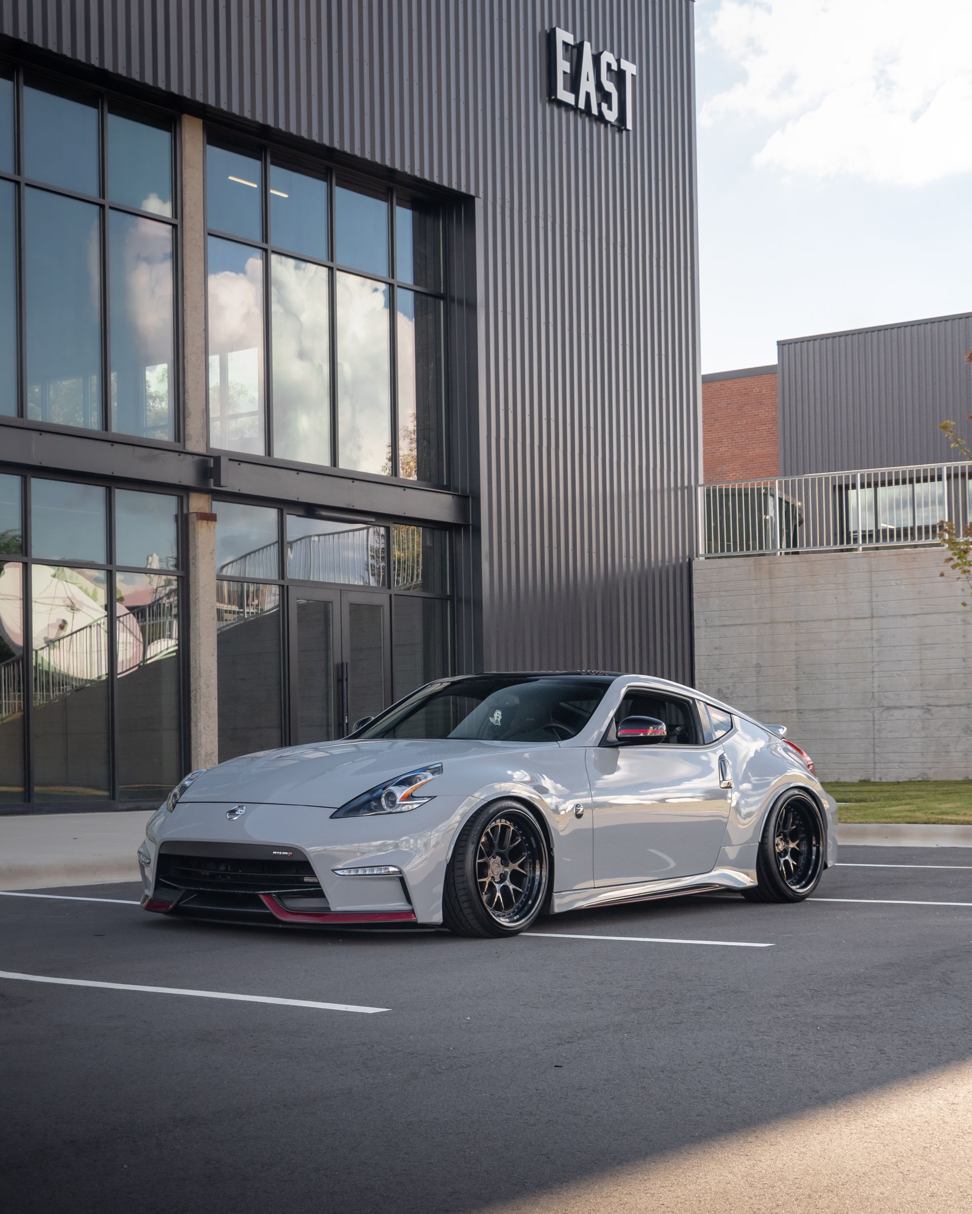 A white sports car is parked in front of a building.