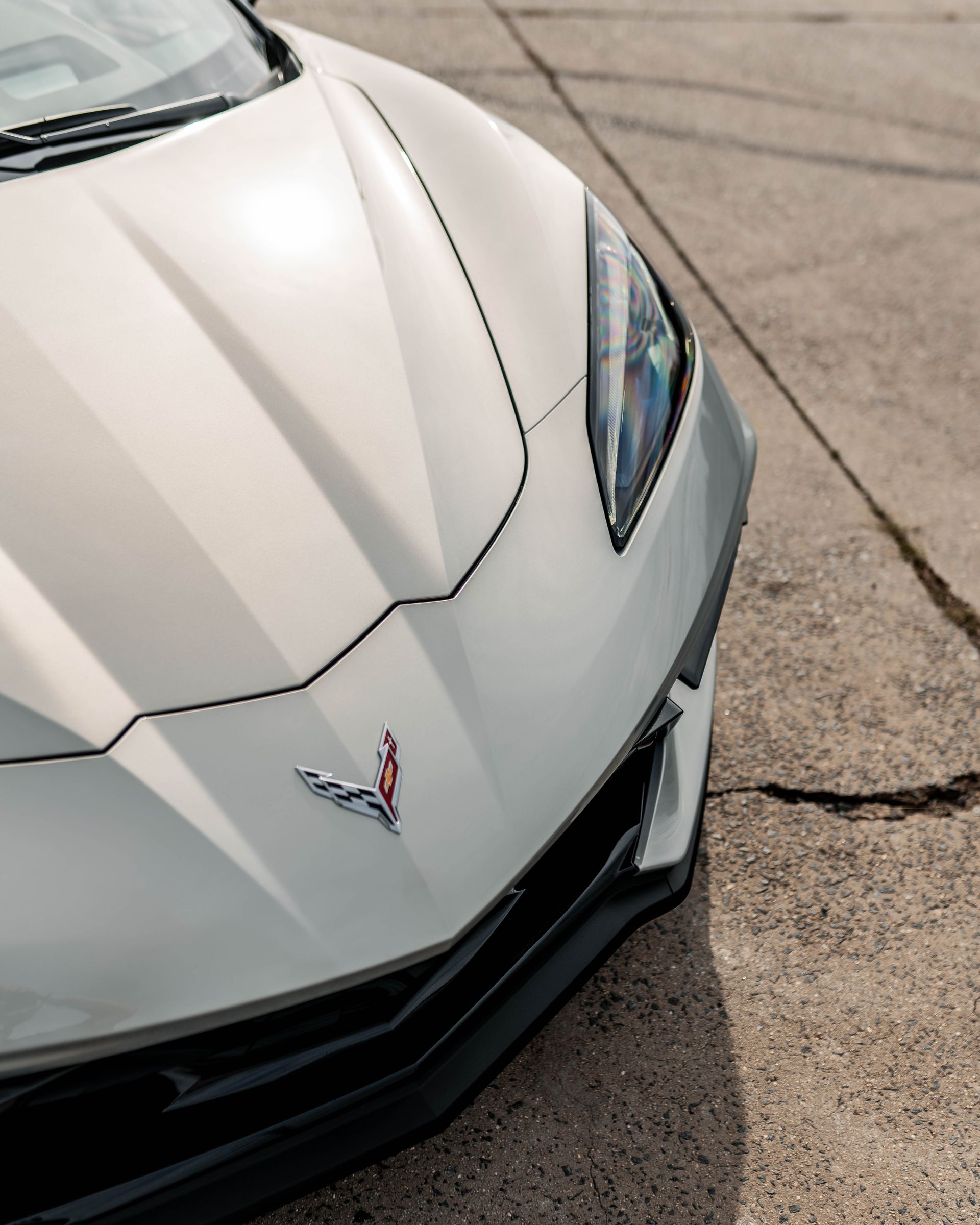 A white sports car is parked on the side of the road