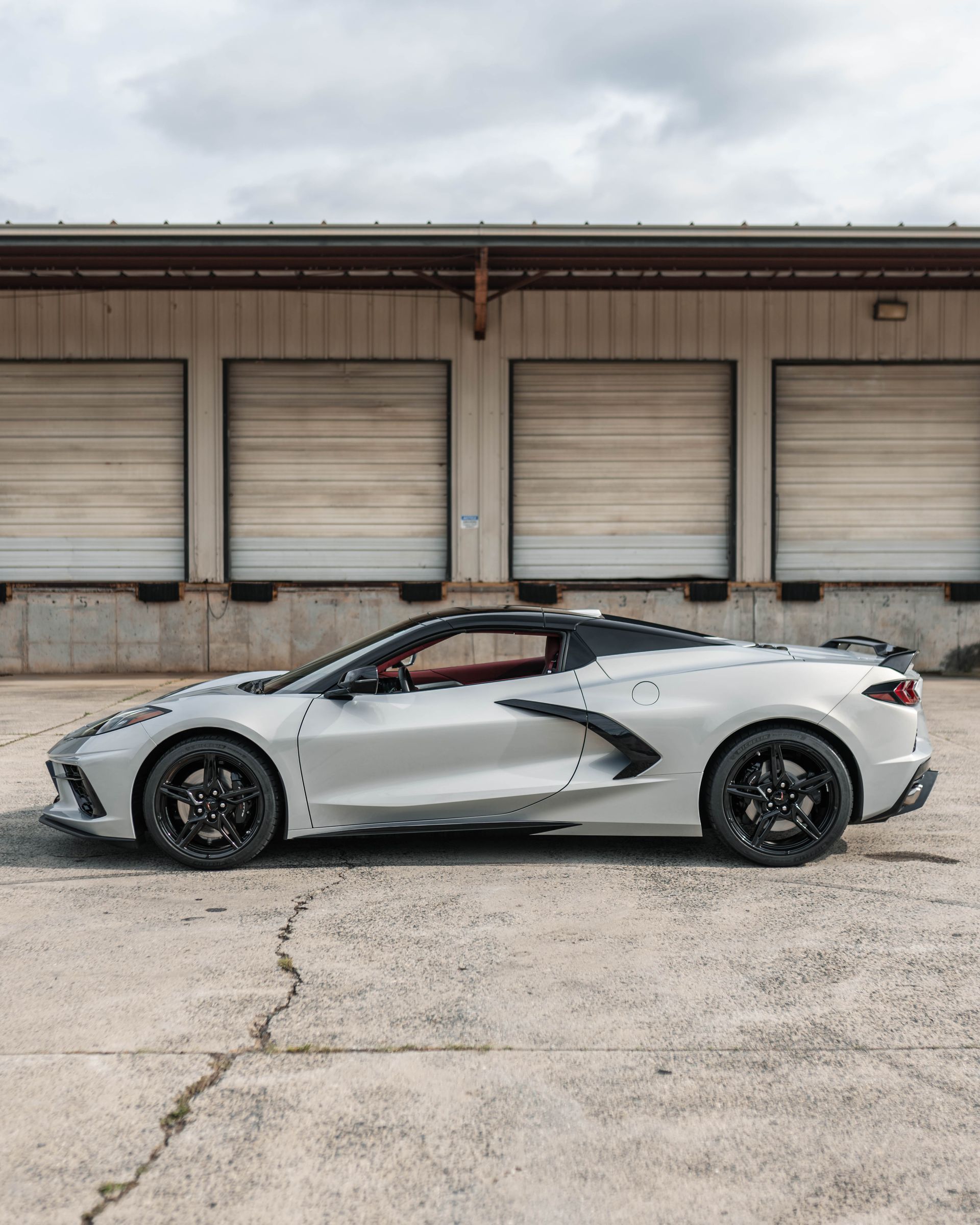 A white sports car is parked in front of a building.
