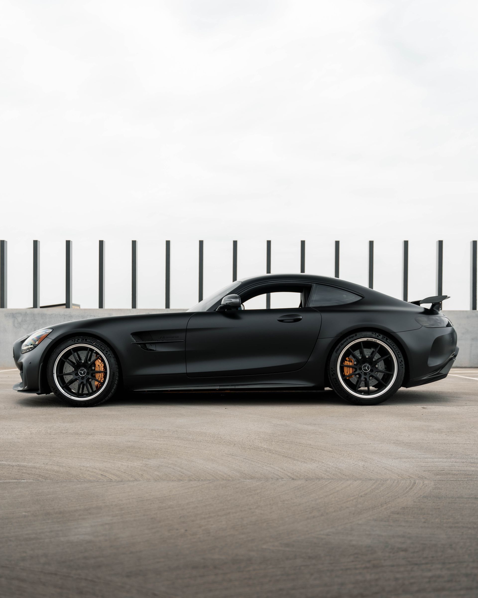 A black sports car is parked in a parking lot.