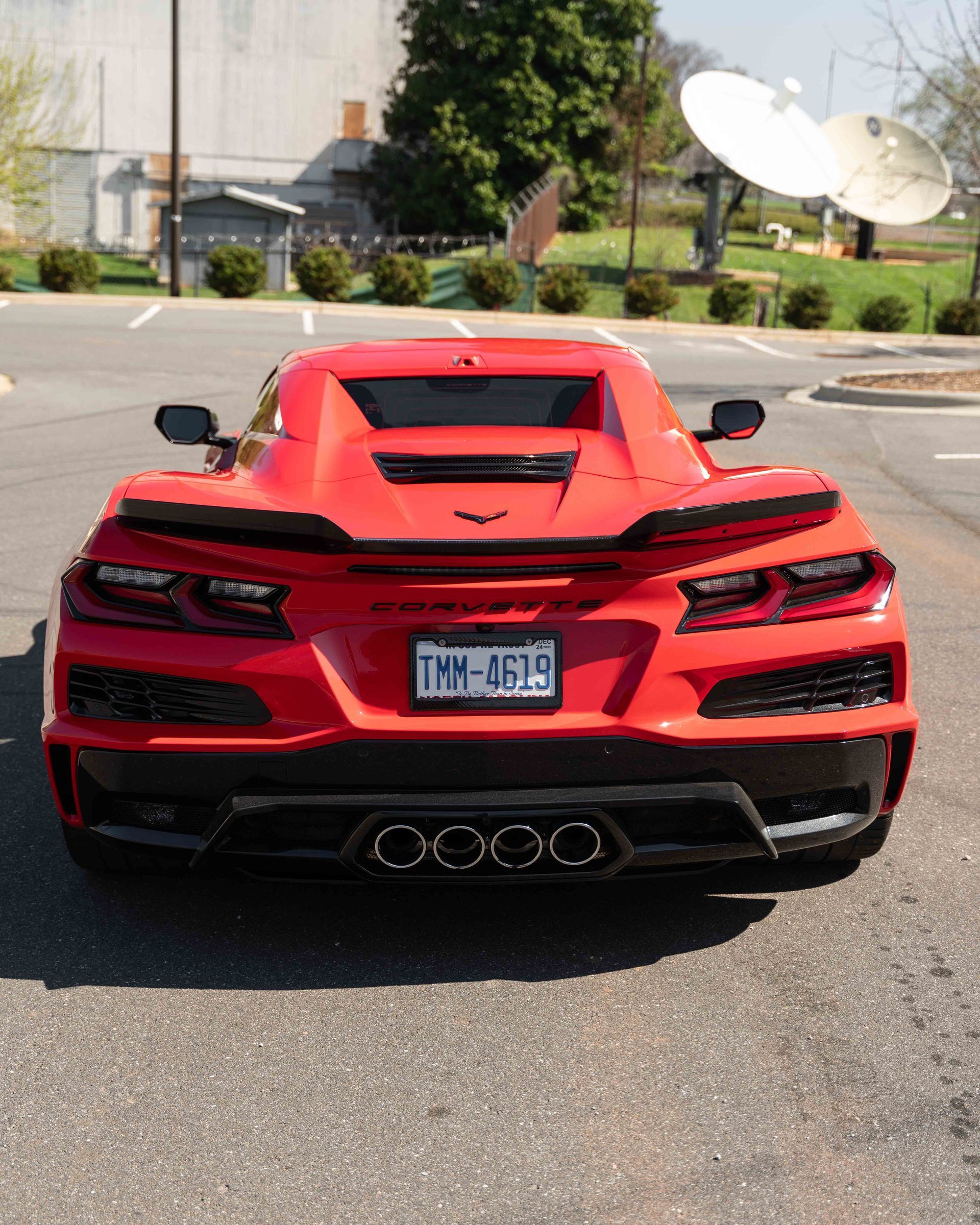 A red sports car with a license plate that says tmm-8519