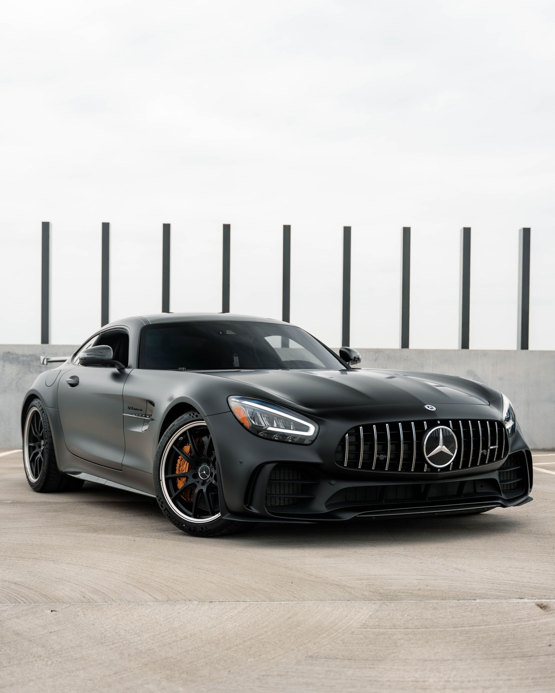 A black mercedes amg gt r is parked in a parking lot.