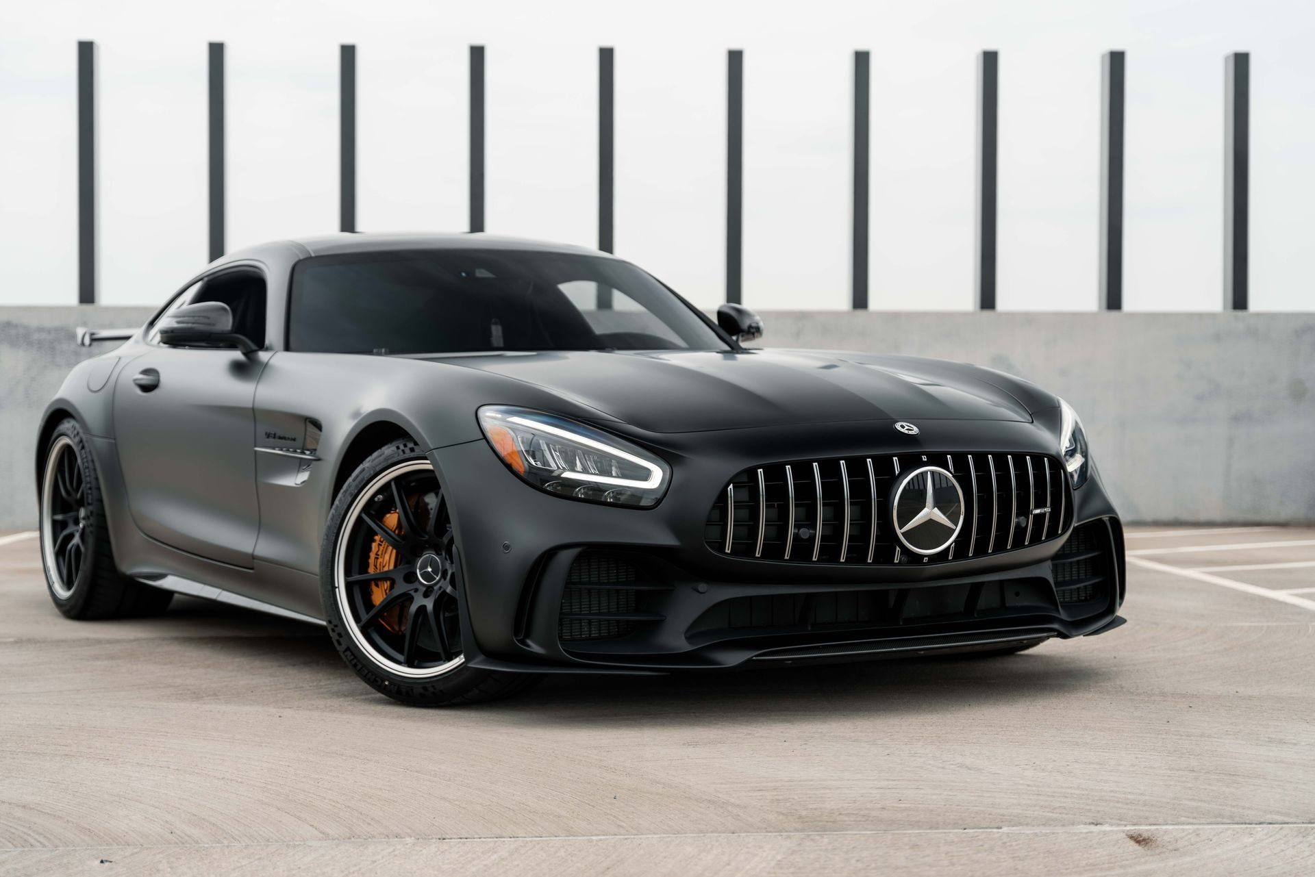 A black mercedes amg gt r is parked in a parking lot.