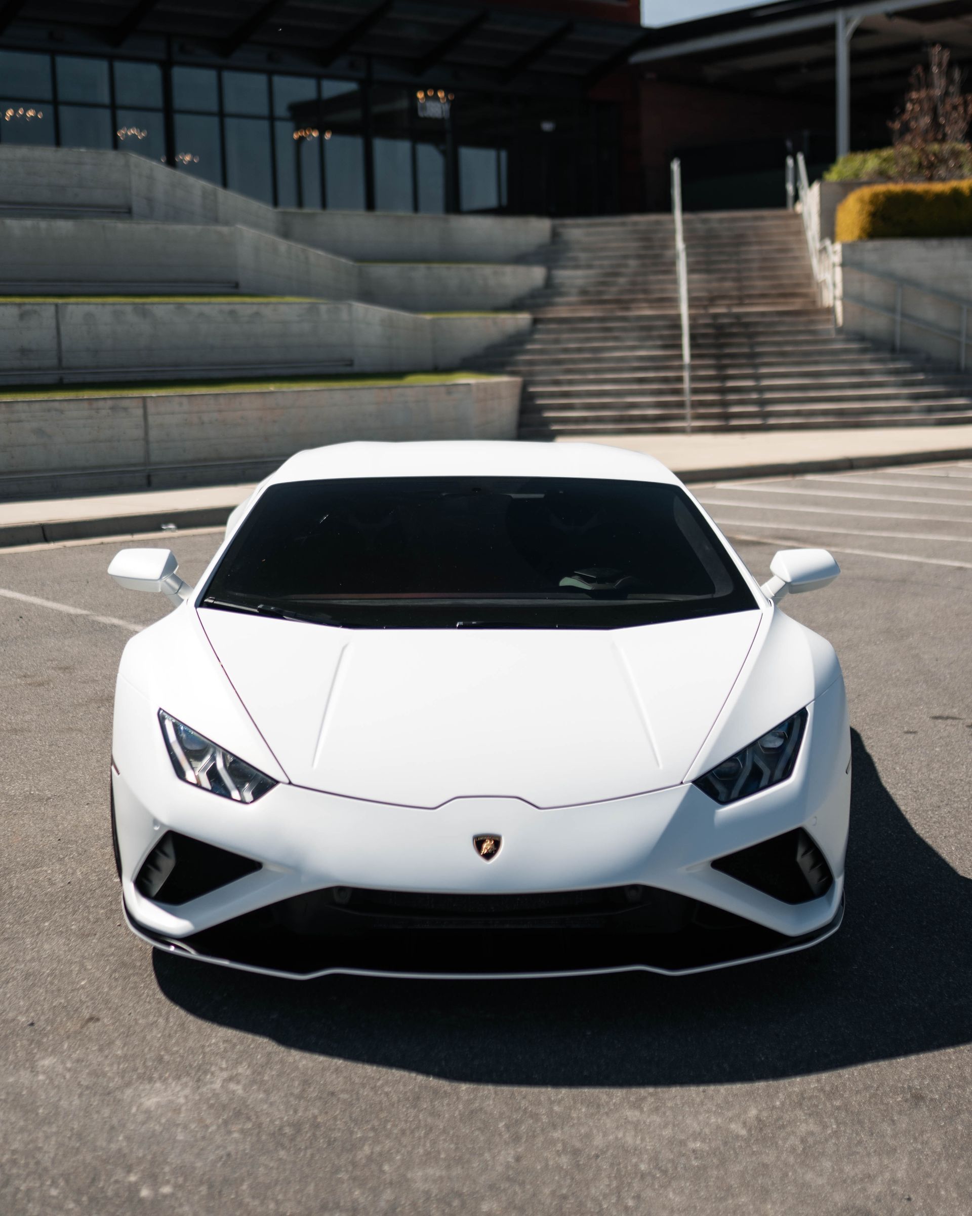 A white sports car is parked in a parking lot
