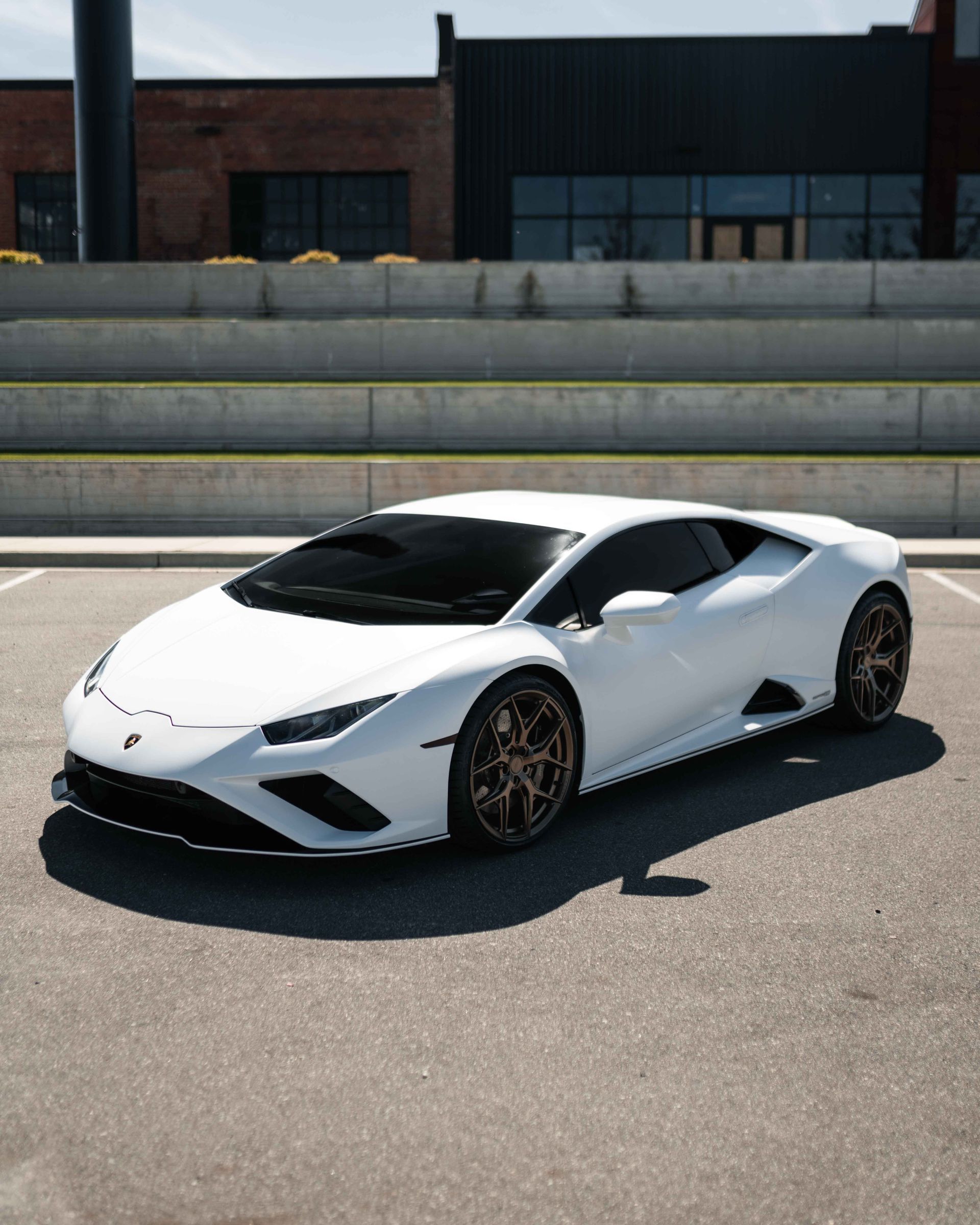 A white lamborghini huracan is parked in a parking lot.