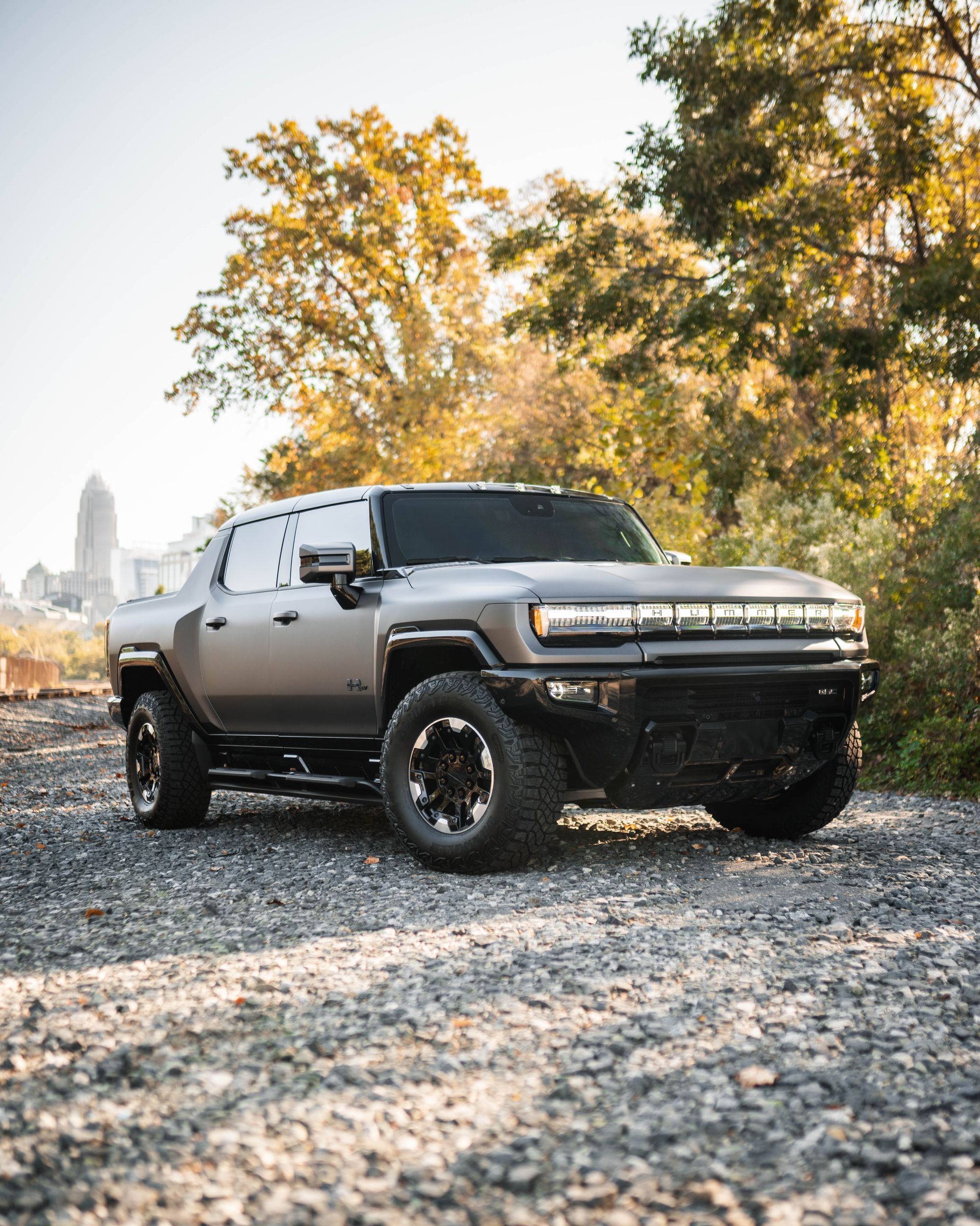 A hummer truck is parked on a gravel road.