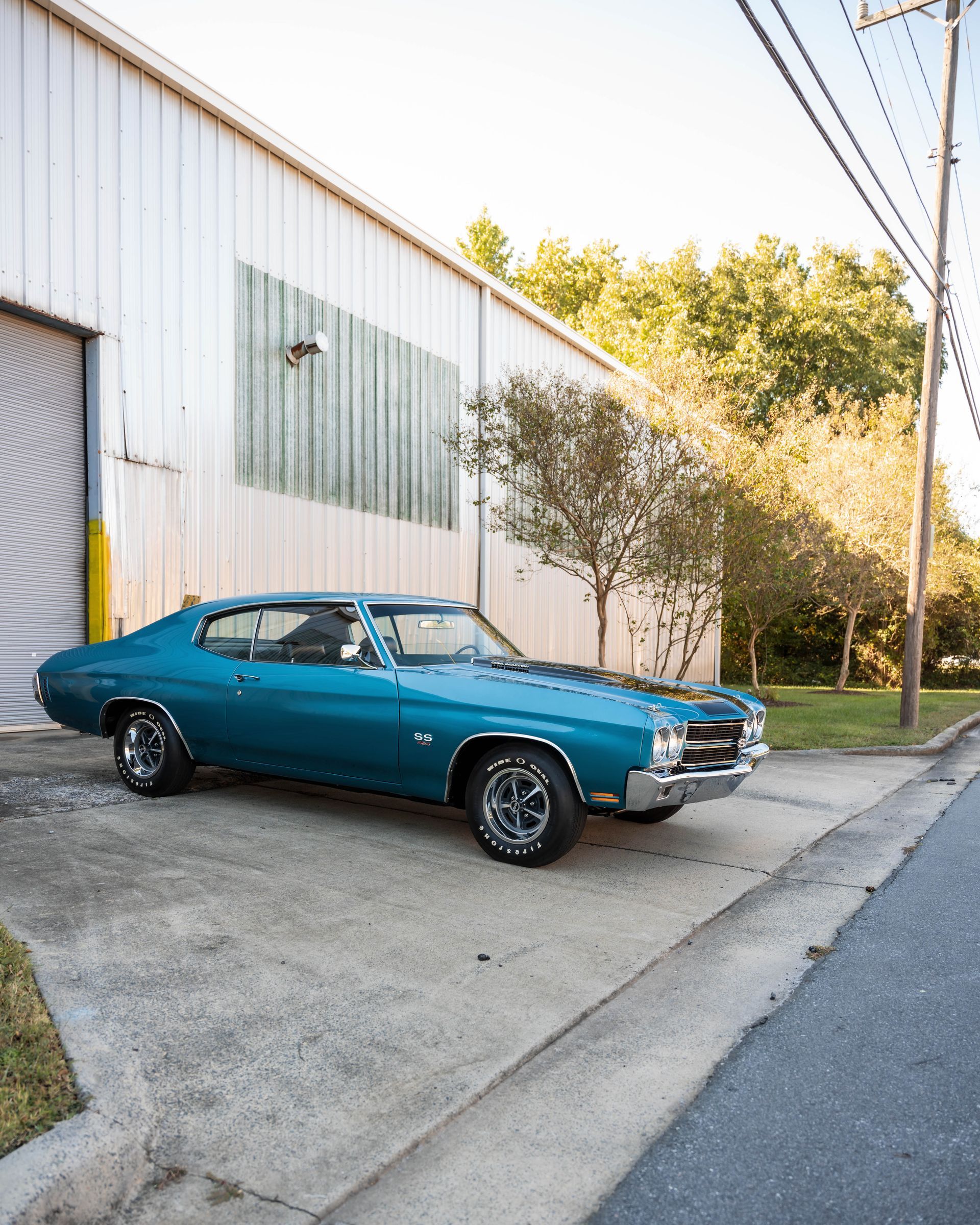 A blue car is parked in front of a building