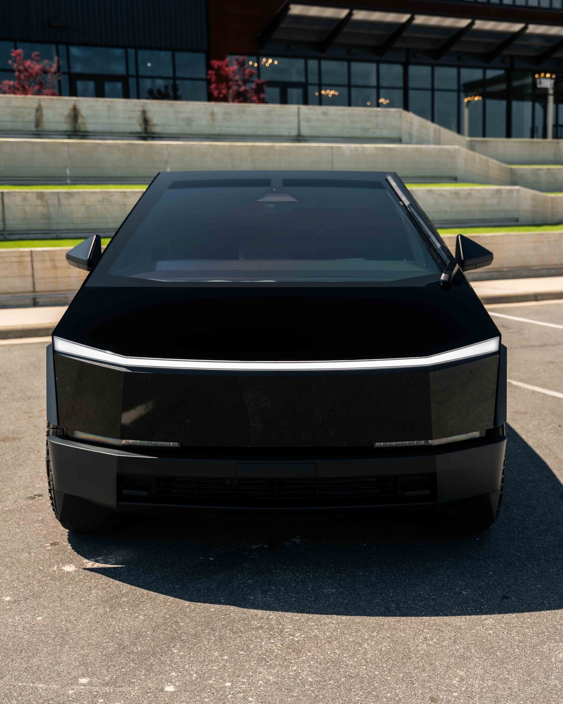A black car is parked in front of a building