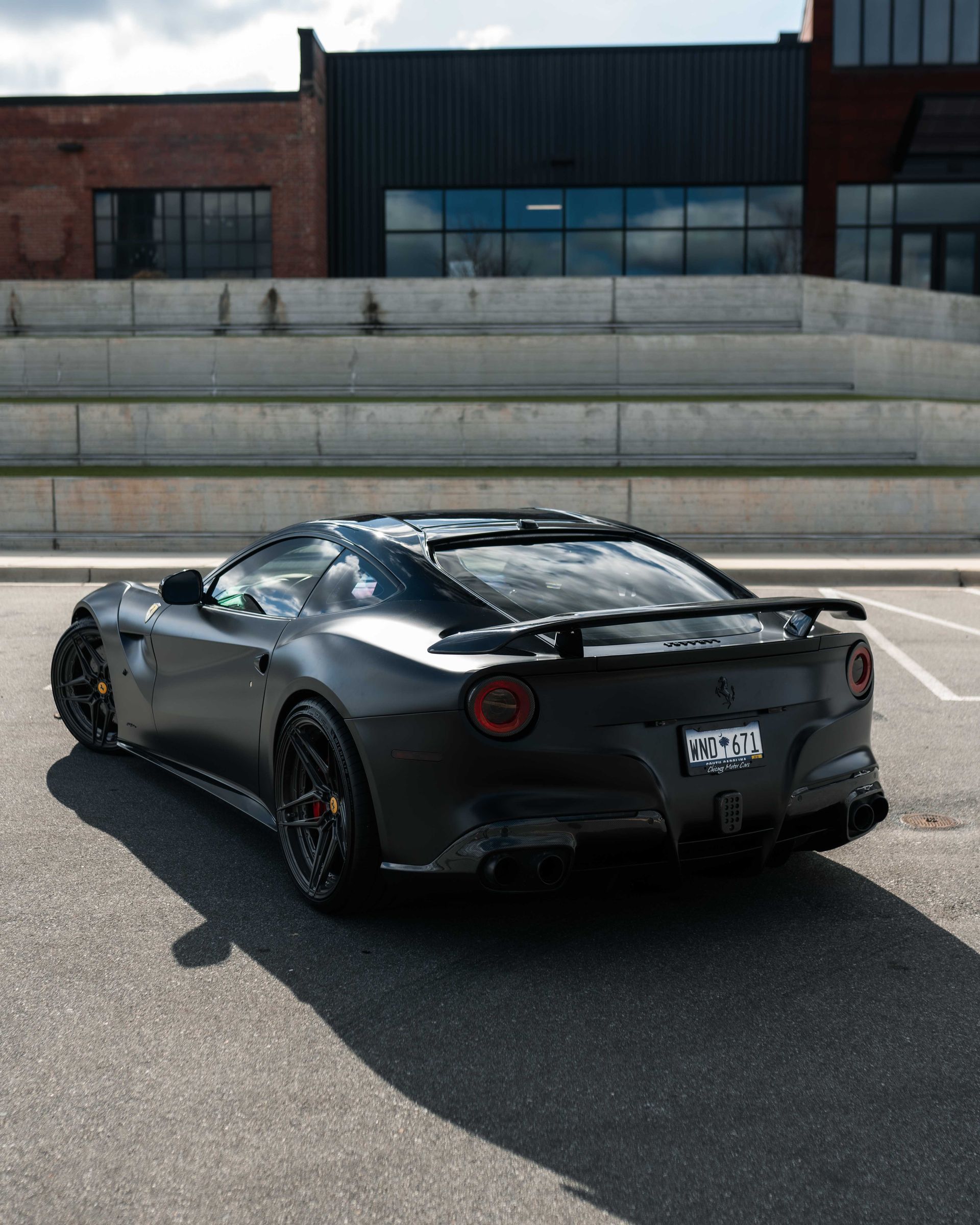 A black sports car is parked in a parking lot