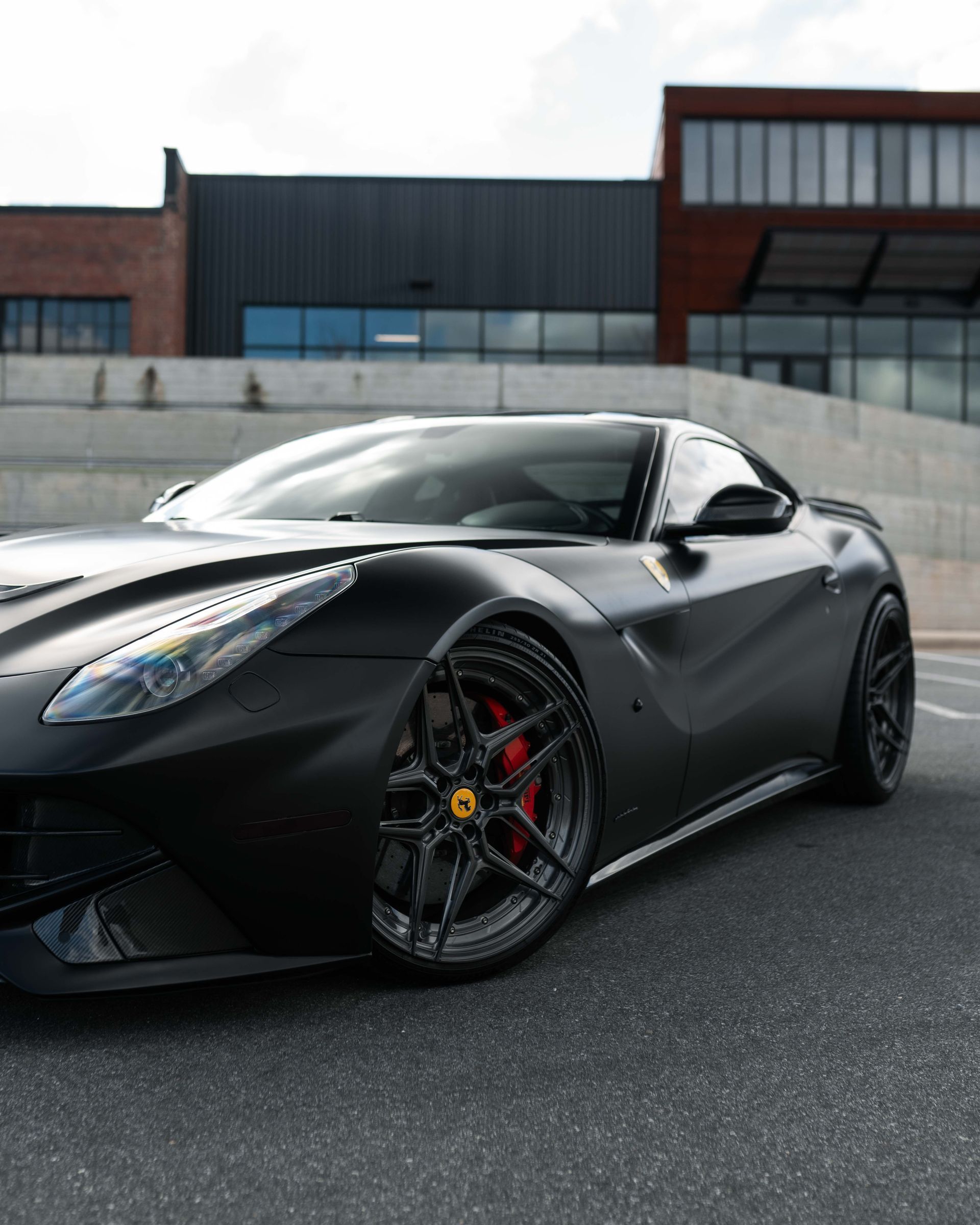 A black sports car is parked in front of a building