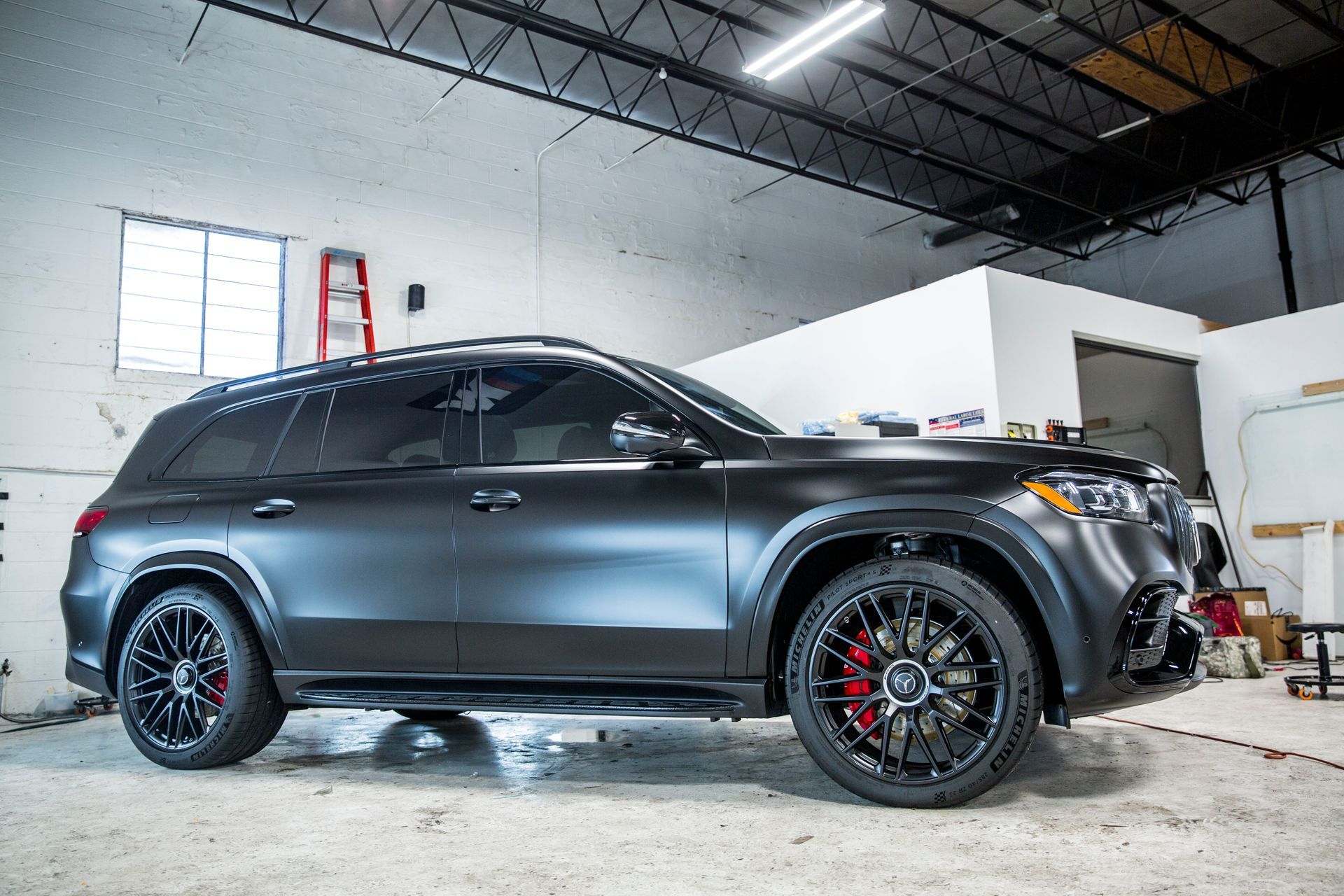 A black suv is parked in a garage.