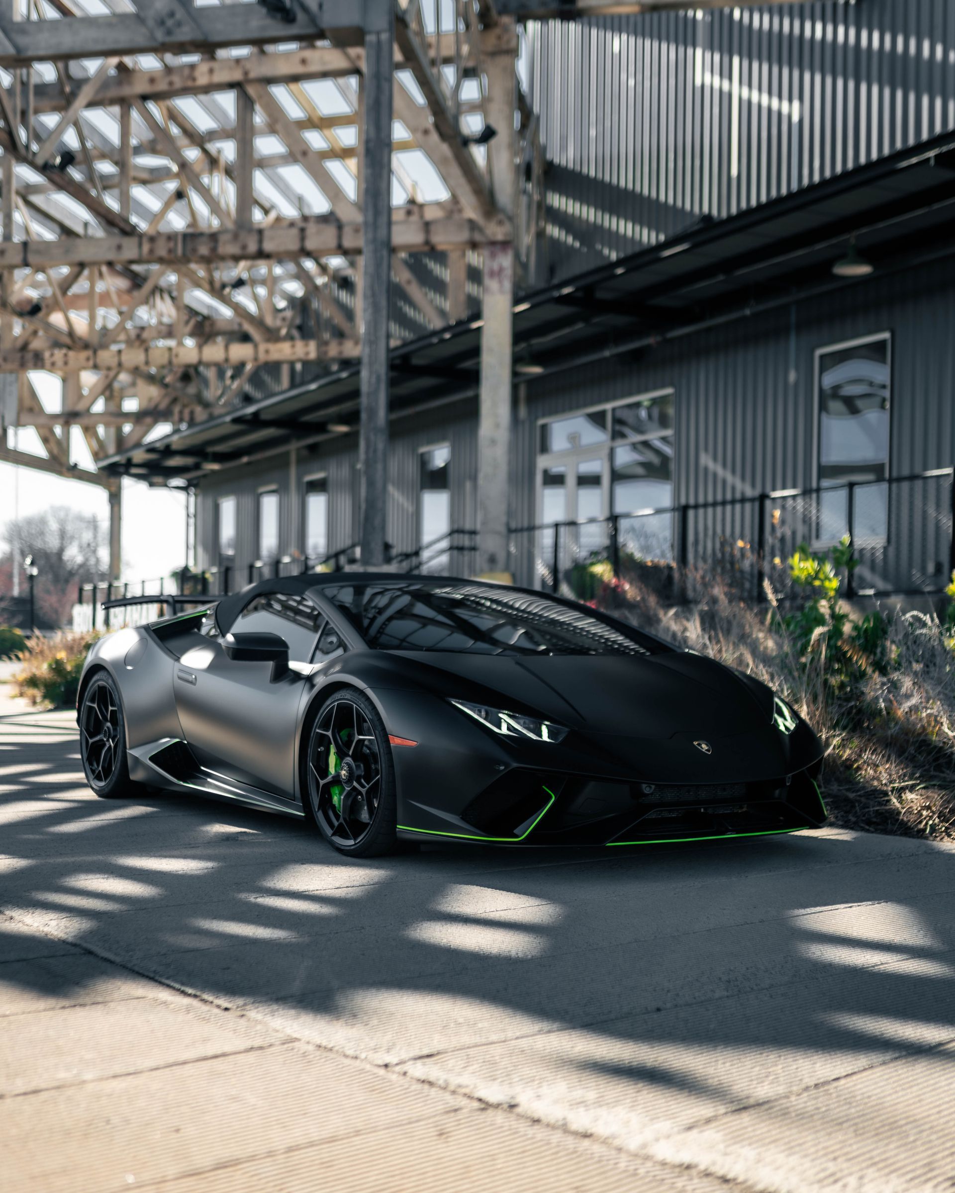 A black lamborghini huracan is parked in front of a building.