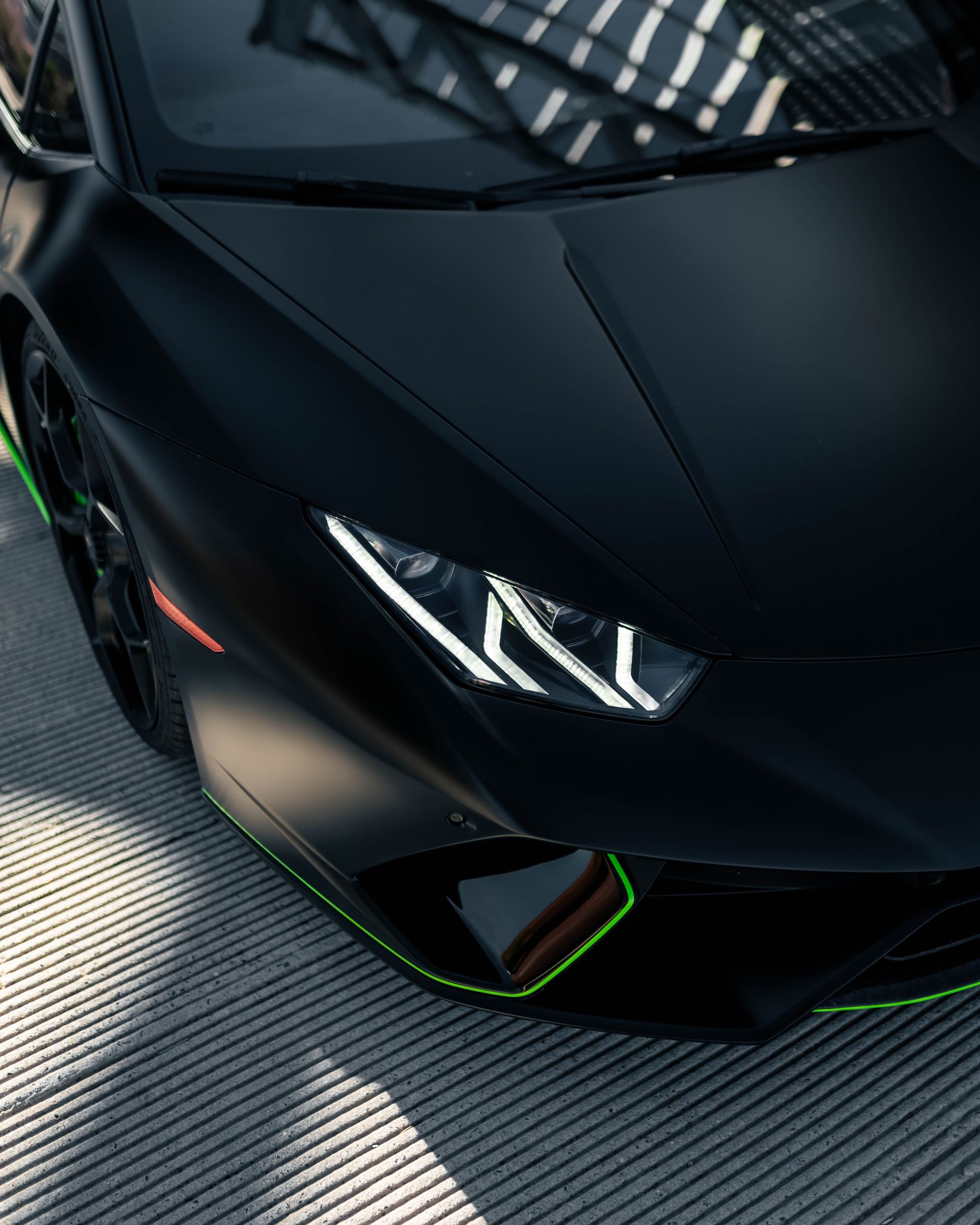 A black sports car with a green stripe on the side