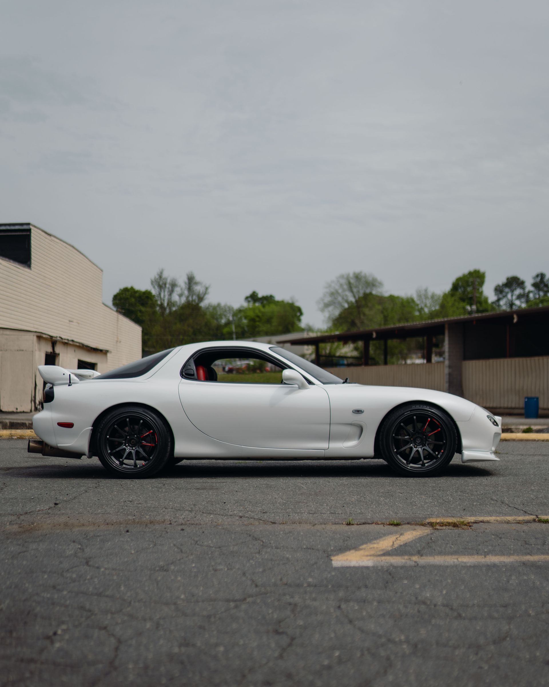 A white sports car is parked in a parking lot