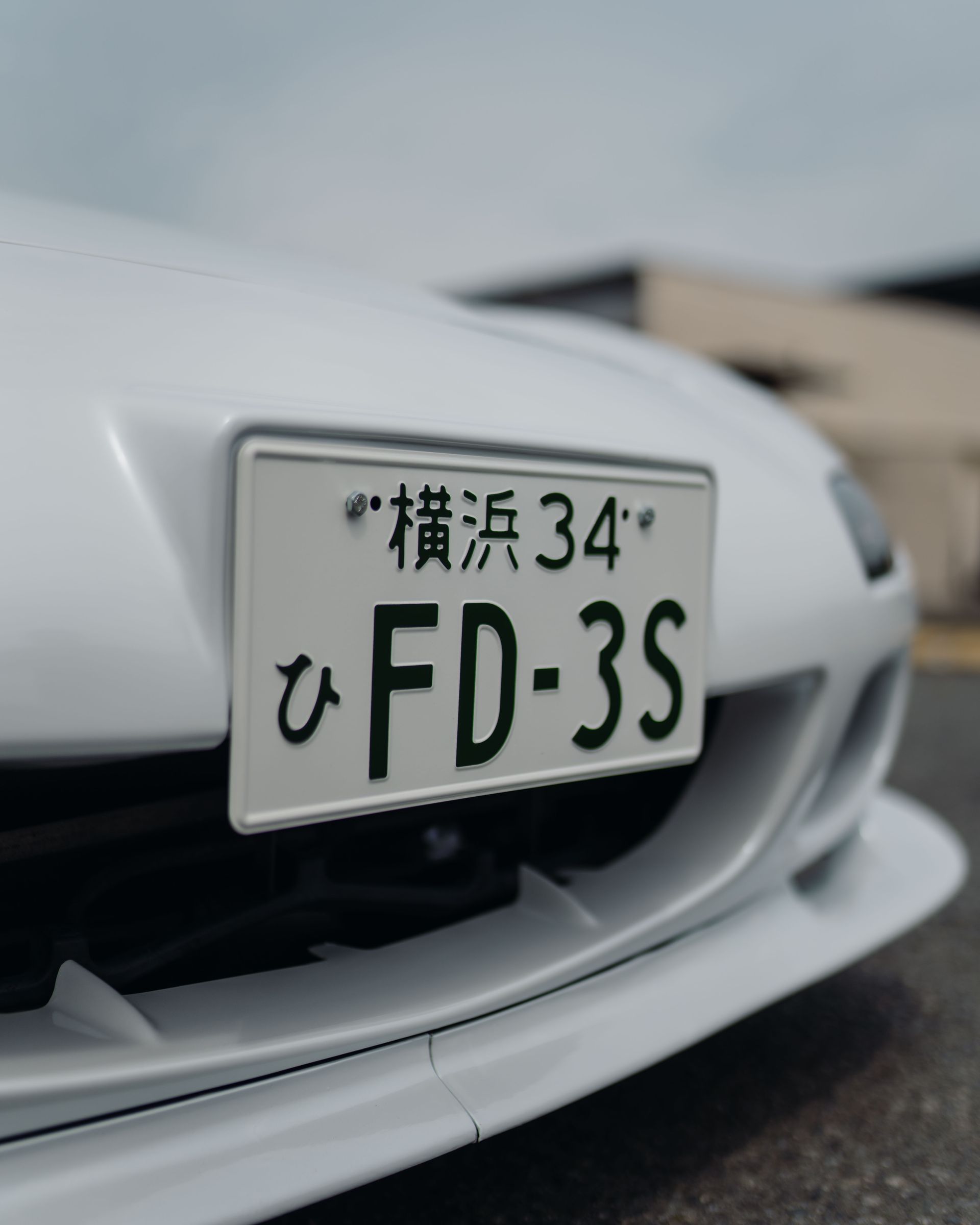 A white car with a license plate that says fd-3s