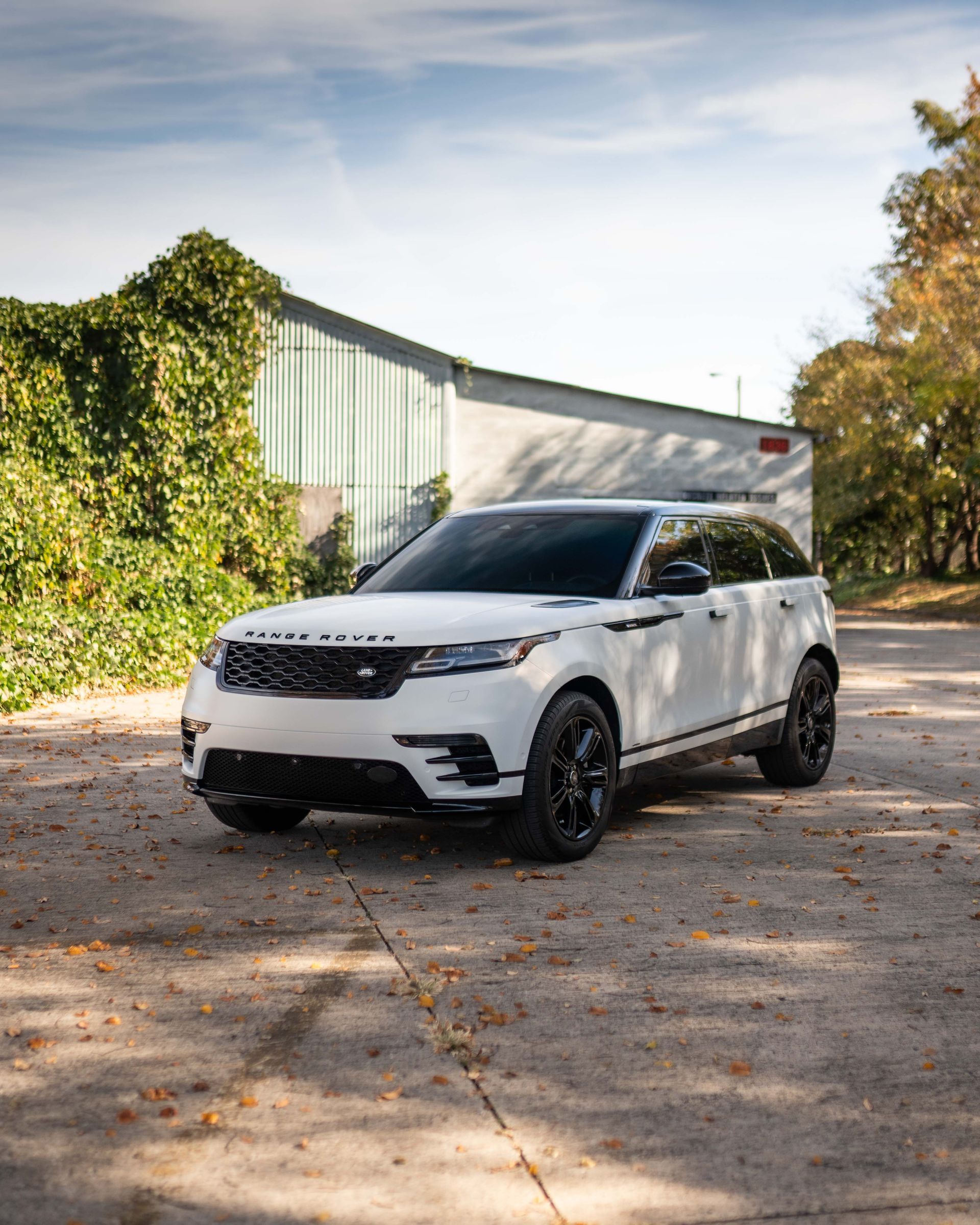 A white range rover velar is parked in a parking lot.