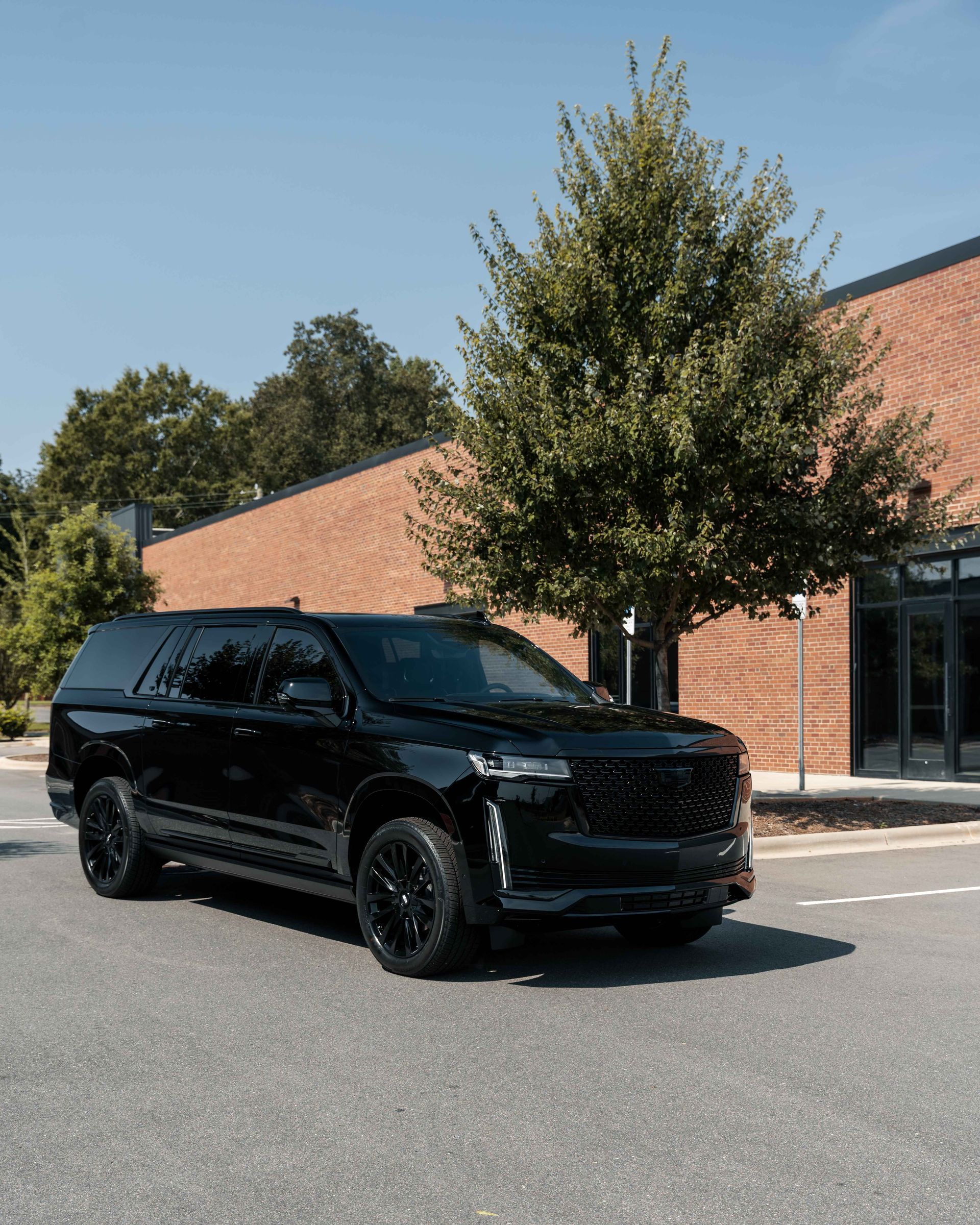 A black suv is parked in front of a brick building