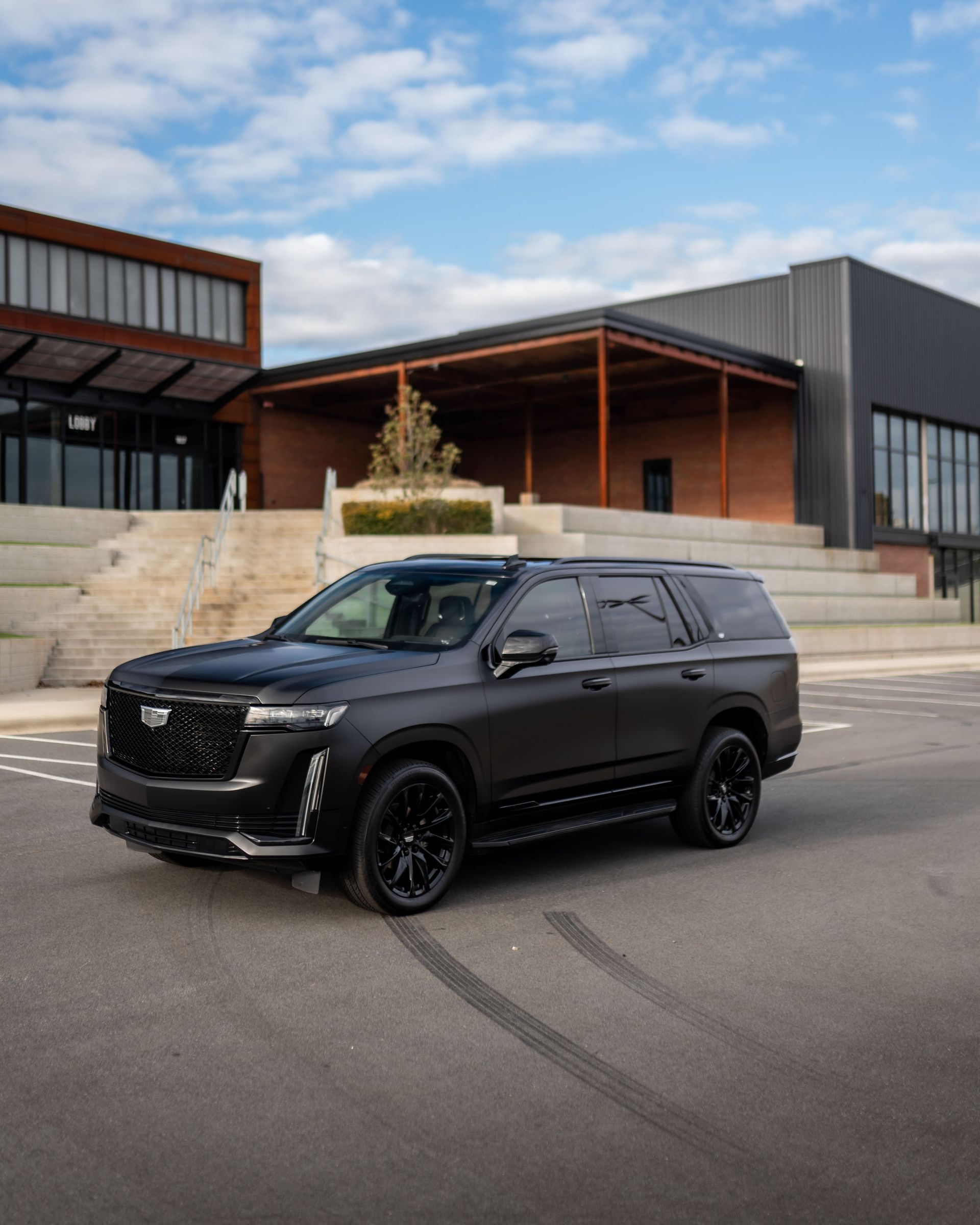 A black suv is parked in front of a building.
