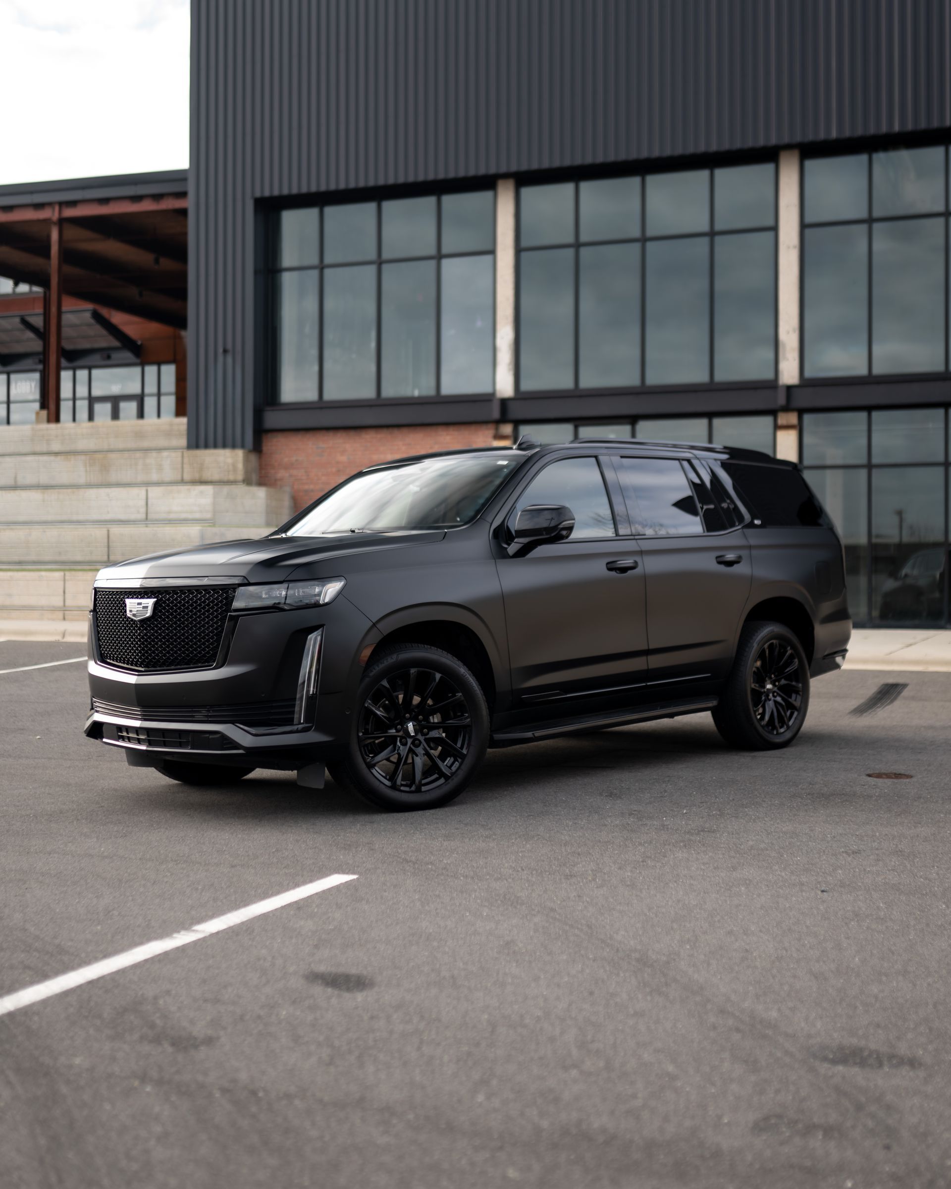 A black suv is parked in front of a building