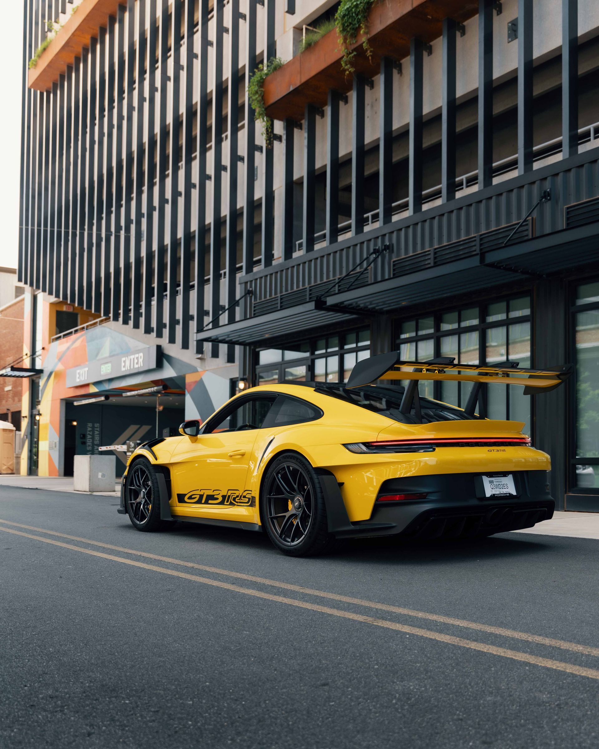 A yellow sports car is parked in front of a building
