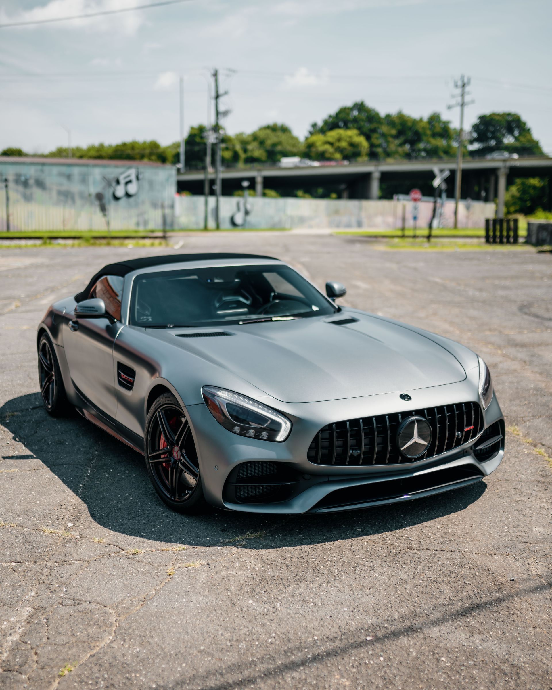 A silver sports car is parked in a parking lot.