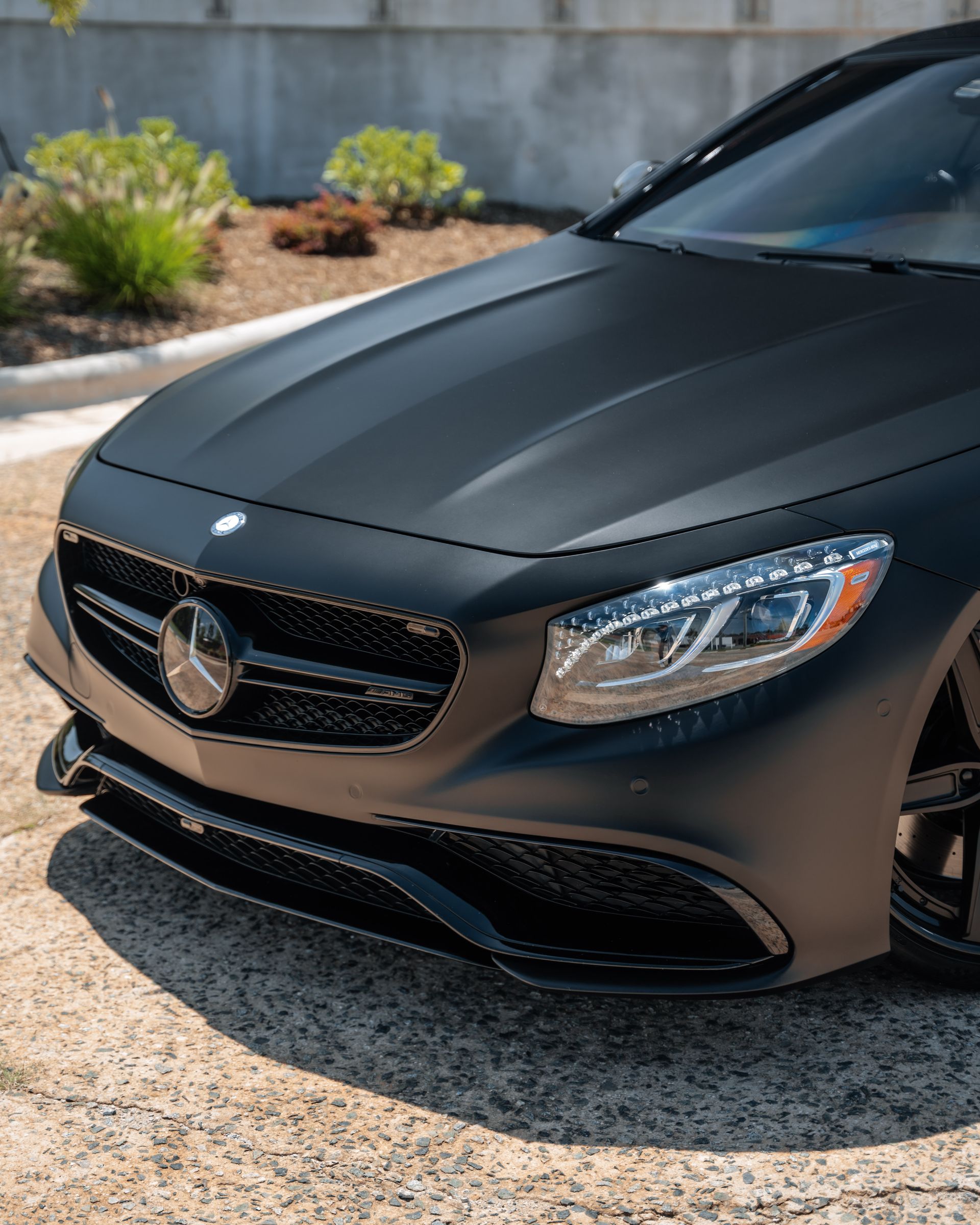 A black mercedes benz s63 amg is parked on the side of the road.