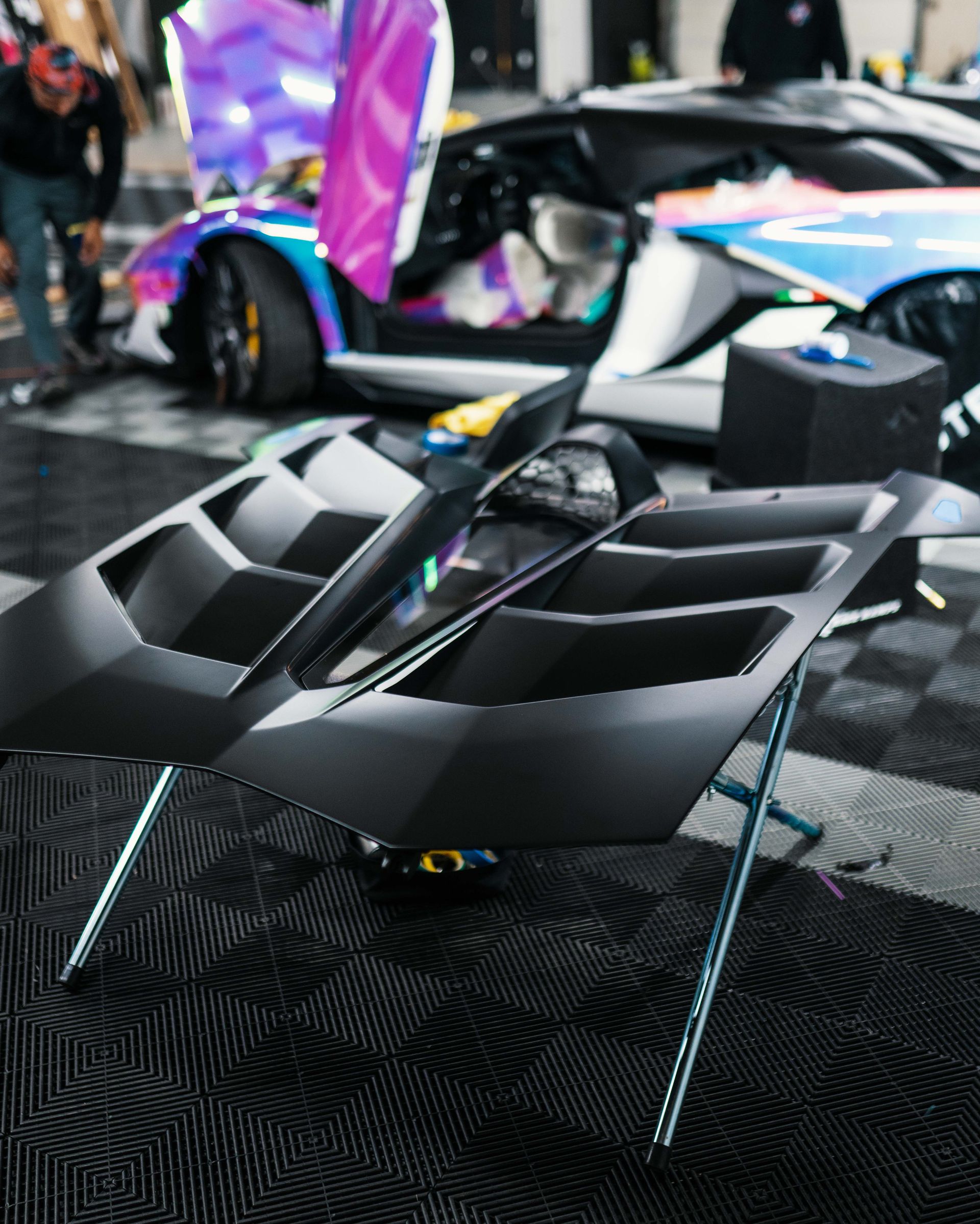 A colorful sports car is parked next to a black chair