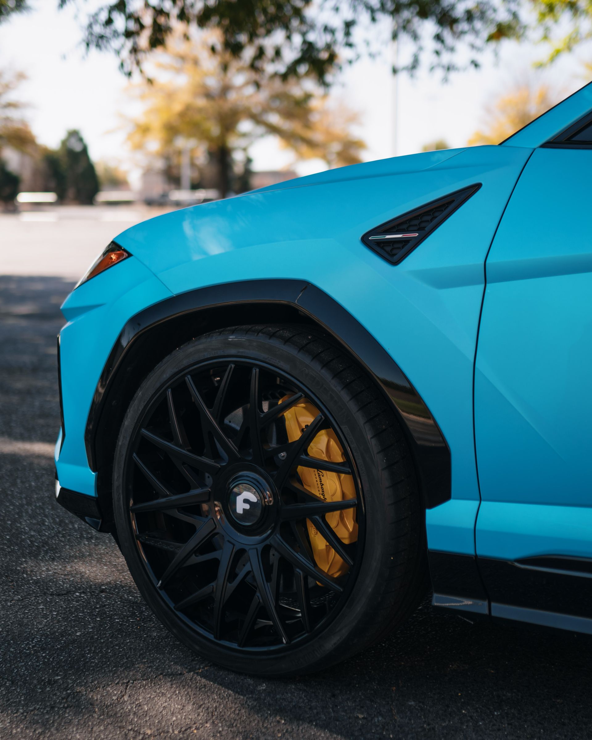 A close up of a blue car with black wheels