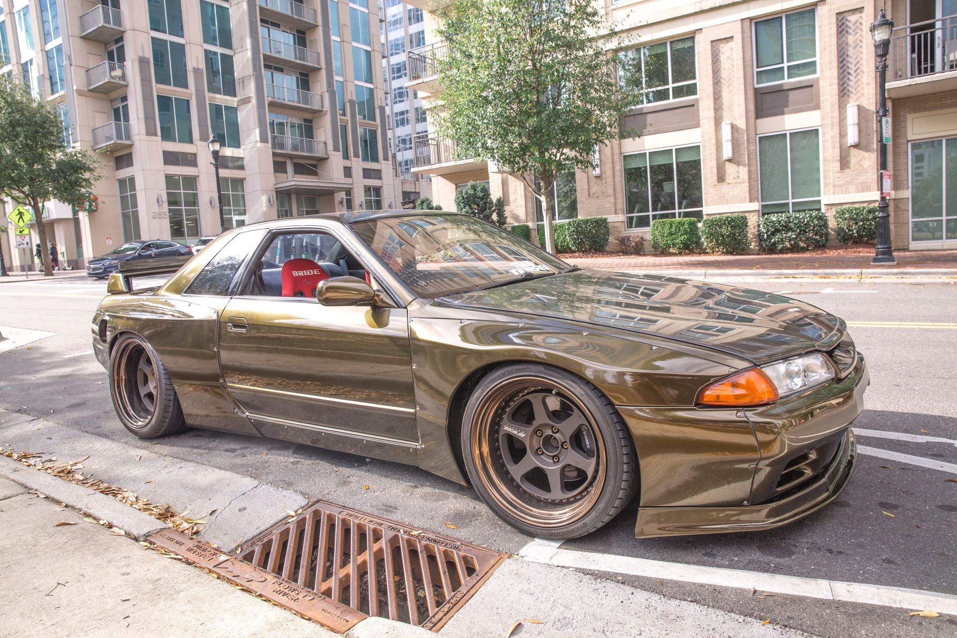 A car is parked on the side of the road in front of a building.