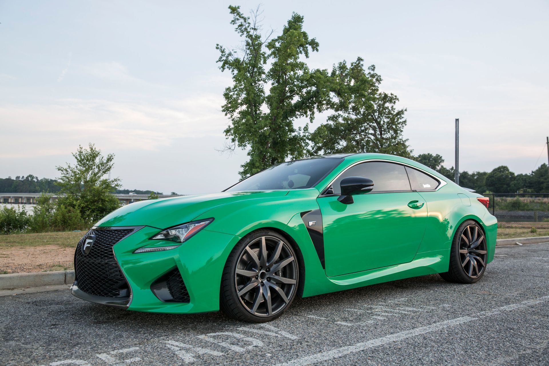 A green lexus rc f sports car is parked in a parking lot.