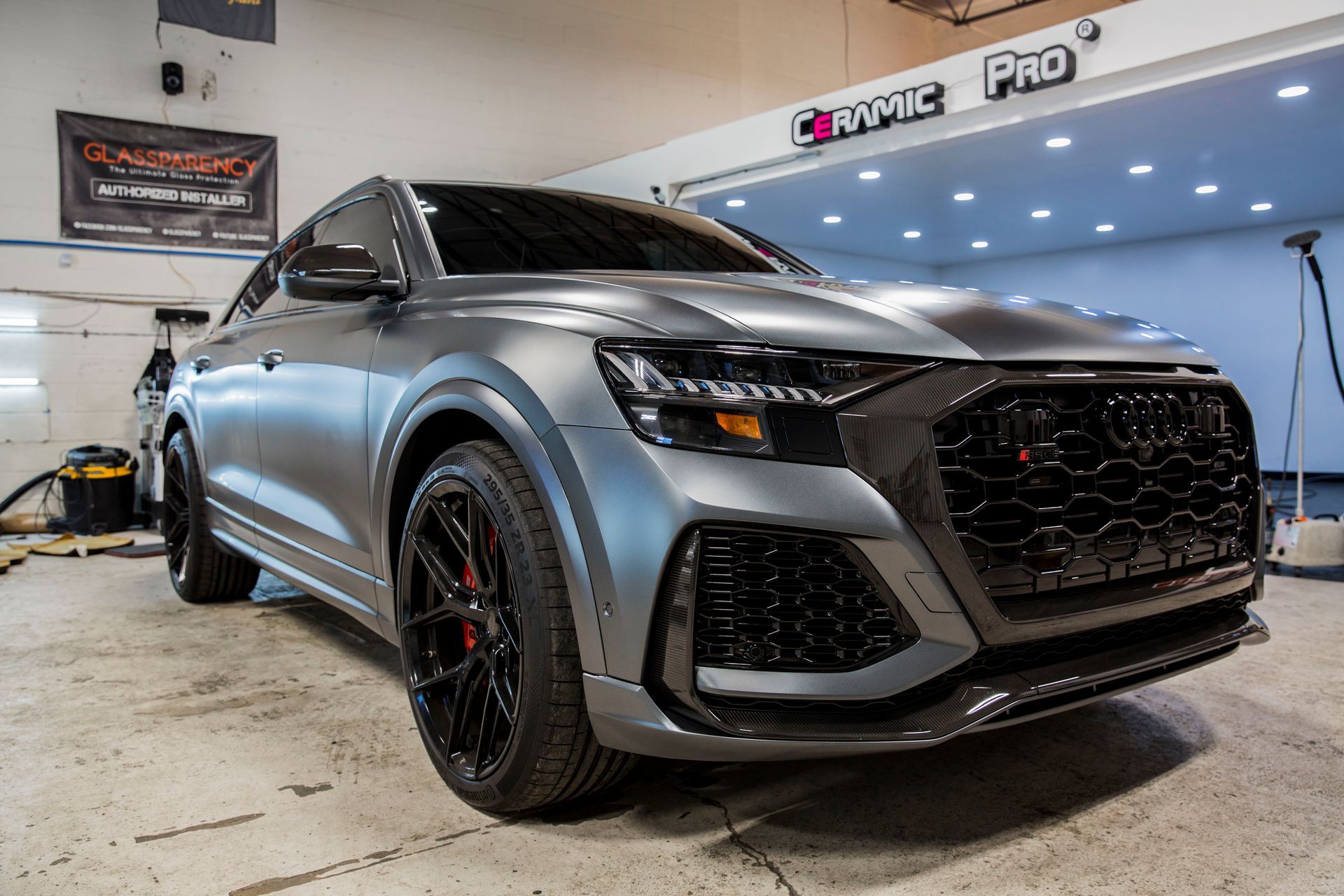 A gray audi q8 rs is parked in a garage.