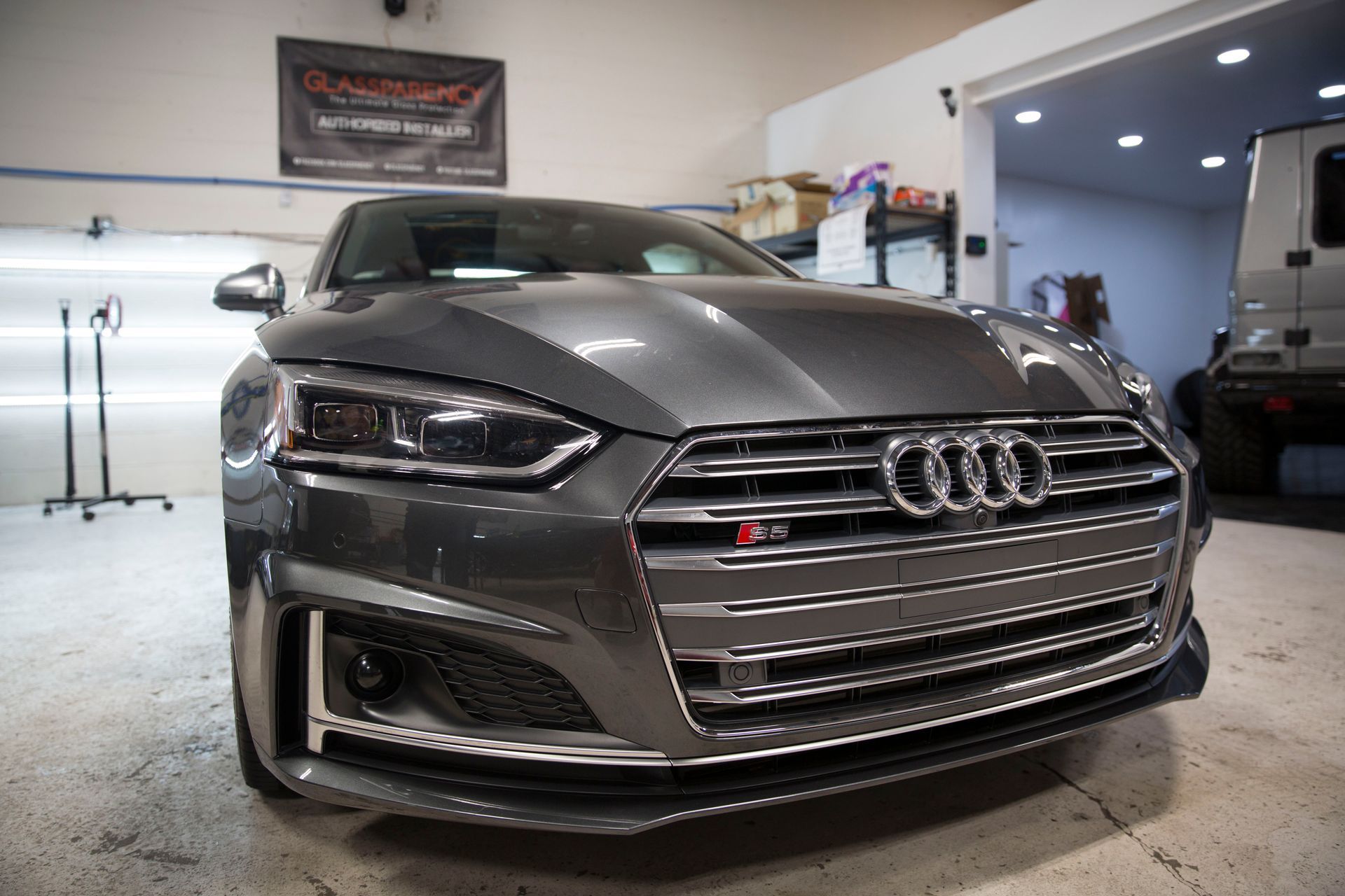 A gray audi s5 is parked in a garage.