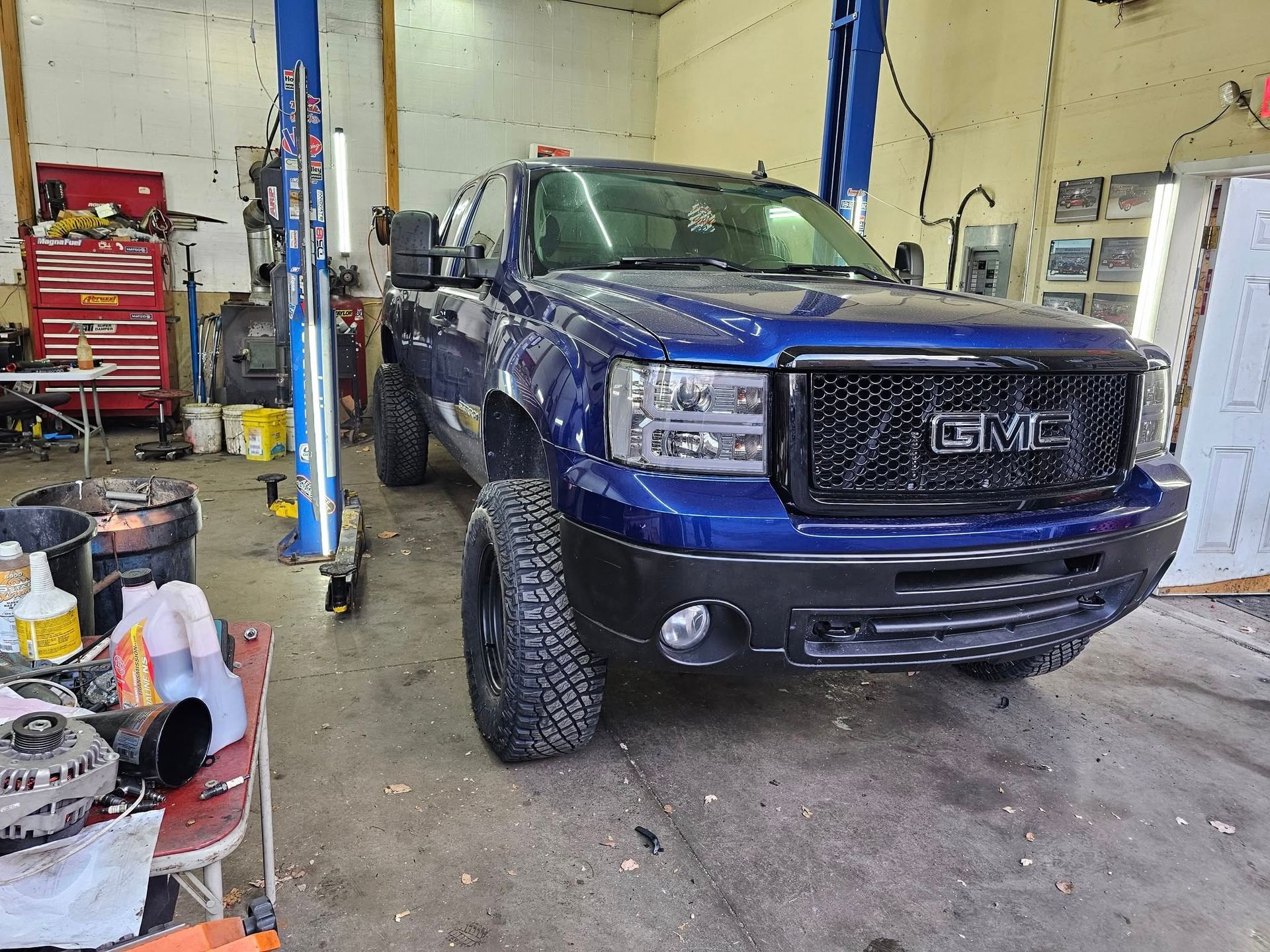 Blue GMC truck in a repair shop.