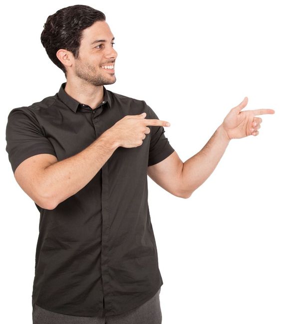Un hombre con cabello oscuro y camisa negra señala hacia la derecha, sonriendo.