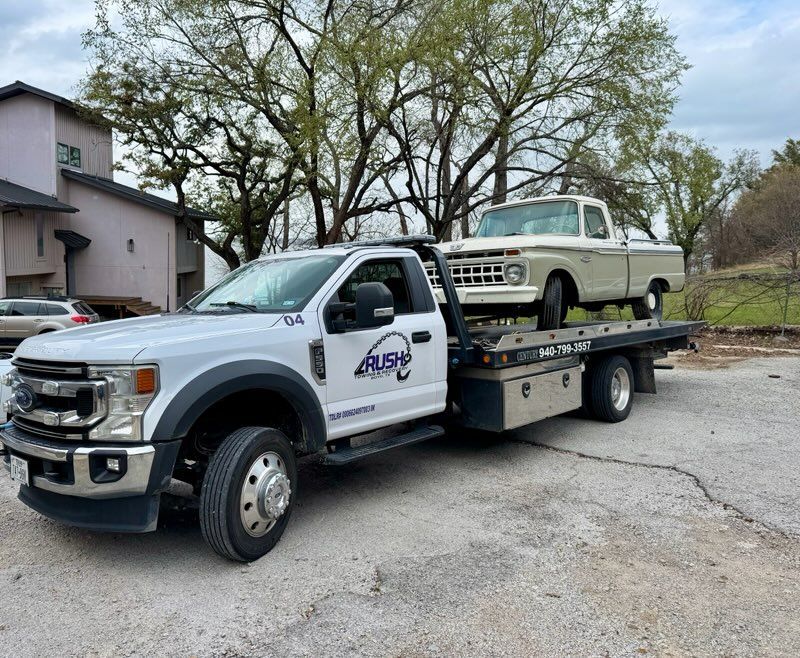 Rusty red vintage Volvo P1800 coupe car on a trailer, tied down for transport.