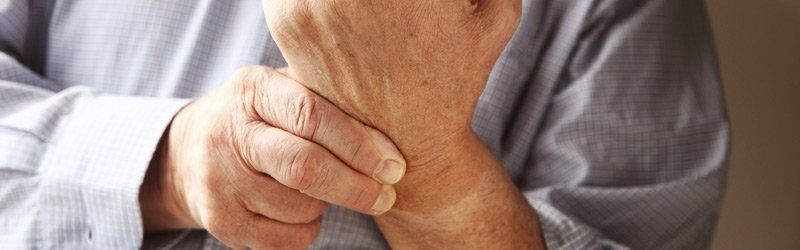 older person grasping their wrist in pain due to carpal tunnel syndrome in The Woodlands, TX