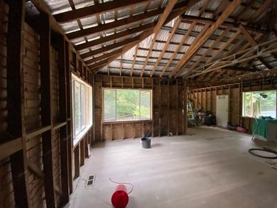 an empty room with a wooden ceiling and a red bucket on the floor .