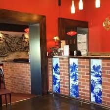 a restaurant with red walls and a brick counter .
