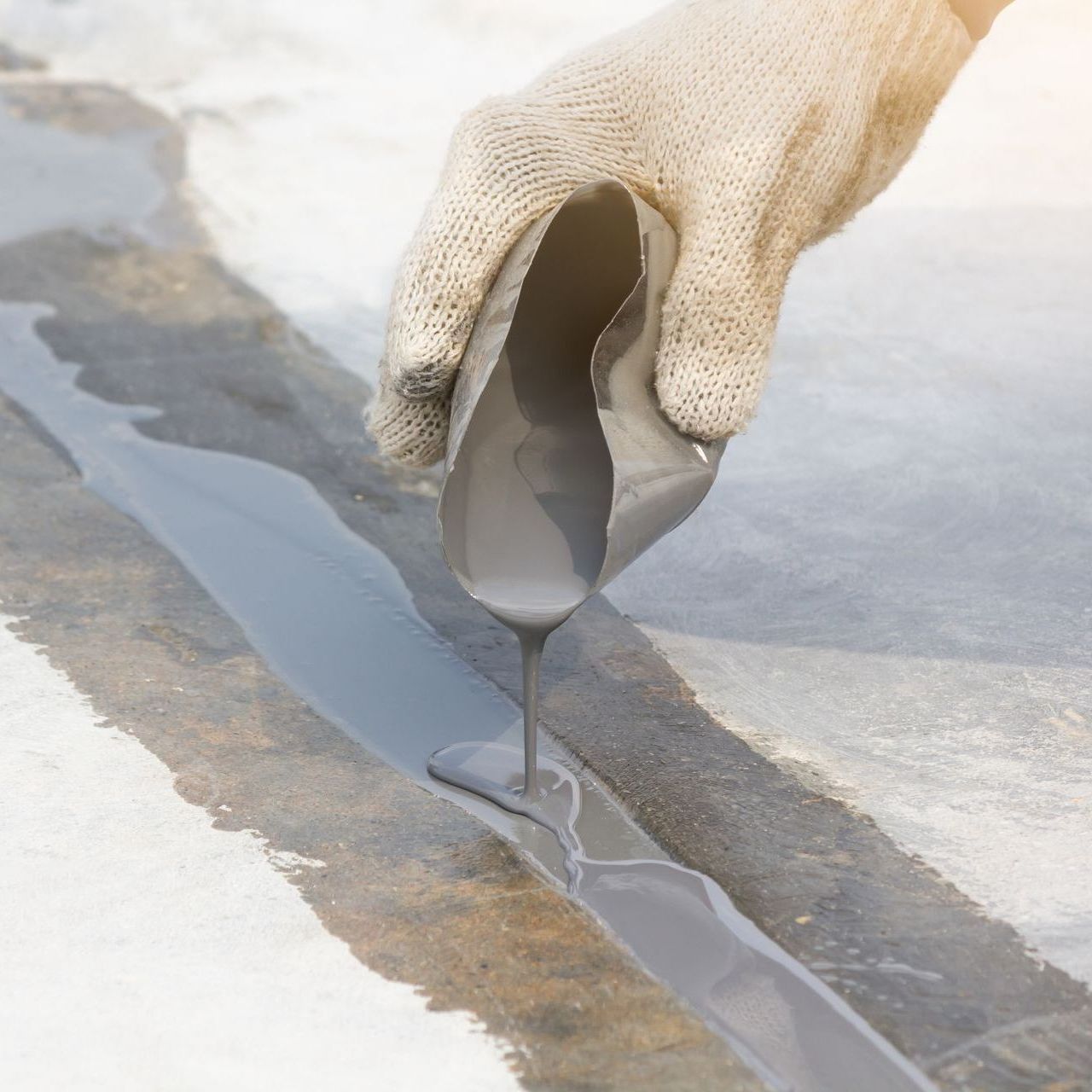 A person is fixing crack in the floor