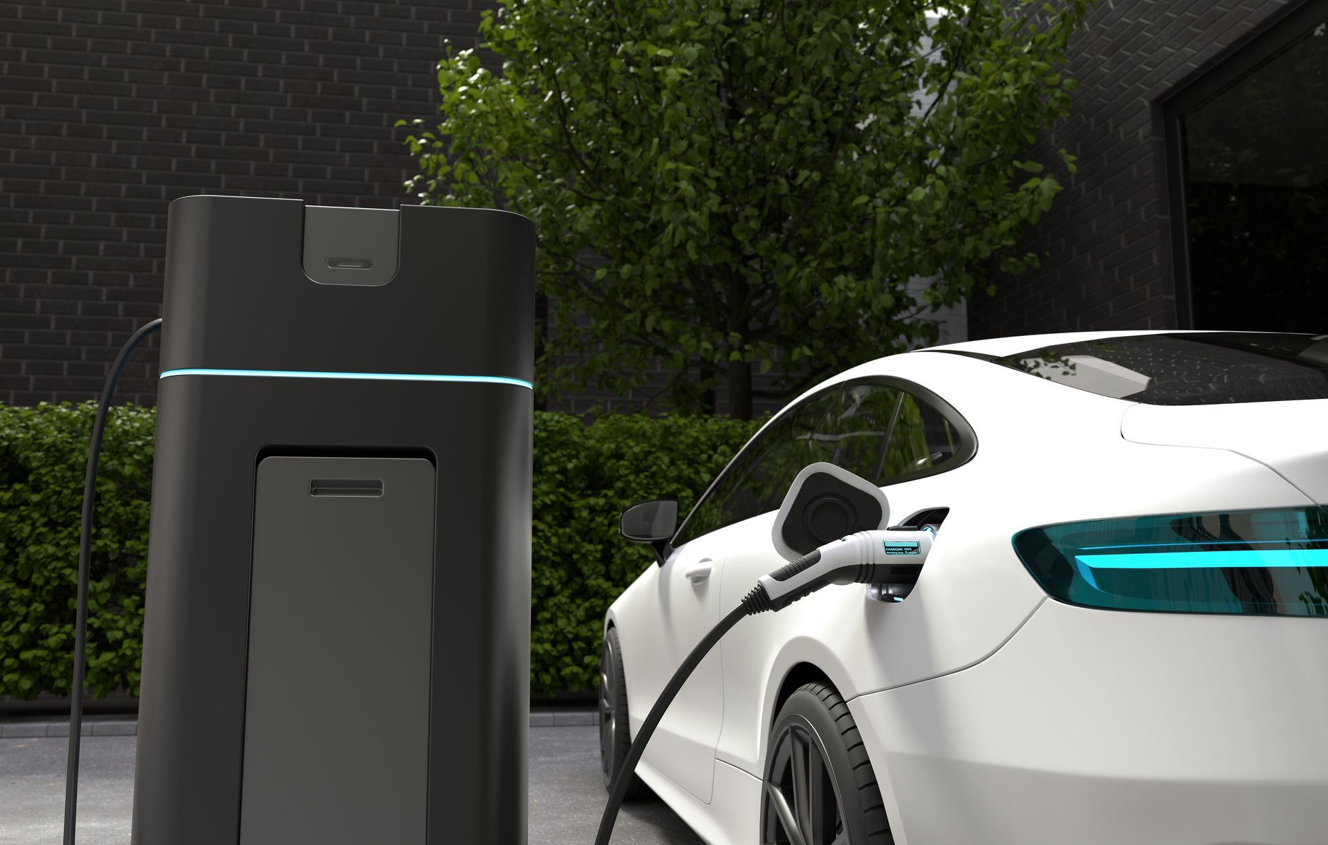 White electric car charging next to a black charging station, outdoors in a residential setting.