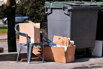 a pile of cardboard boxes sitting next to a trash can