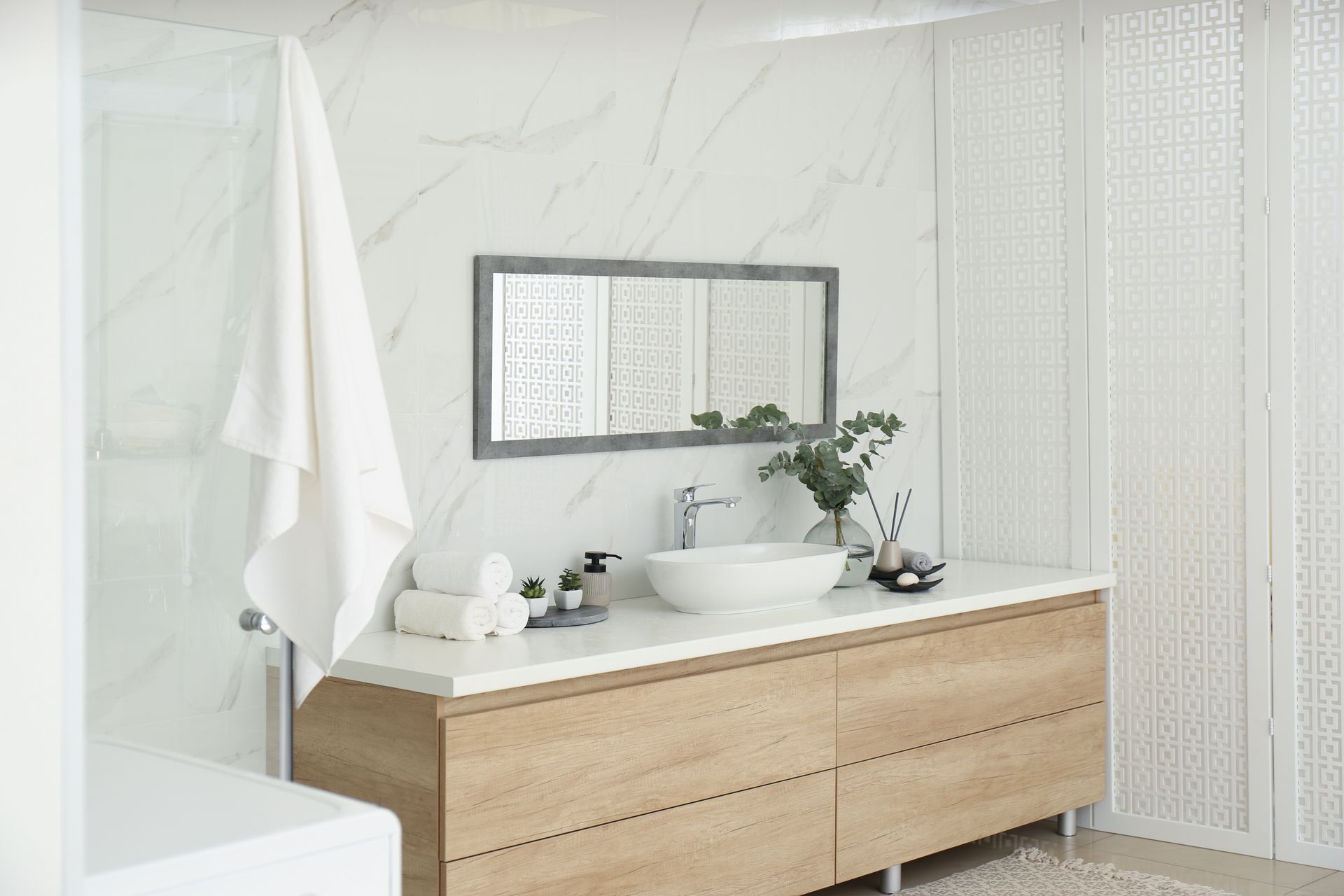 Modern bathroom vanity with wooden cabinets, white sink, mirror, and soft neutral decor — Hinch Plumbing In Breakwater, VIC