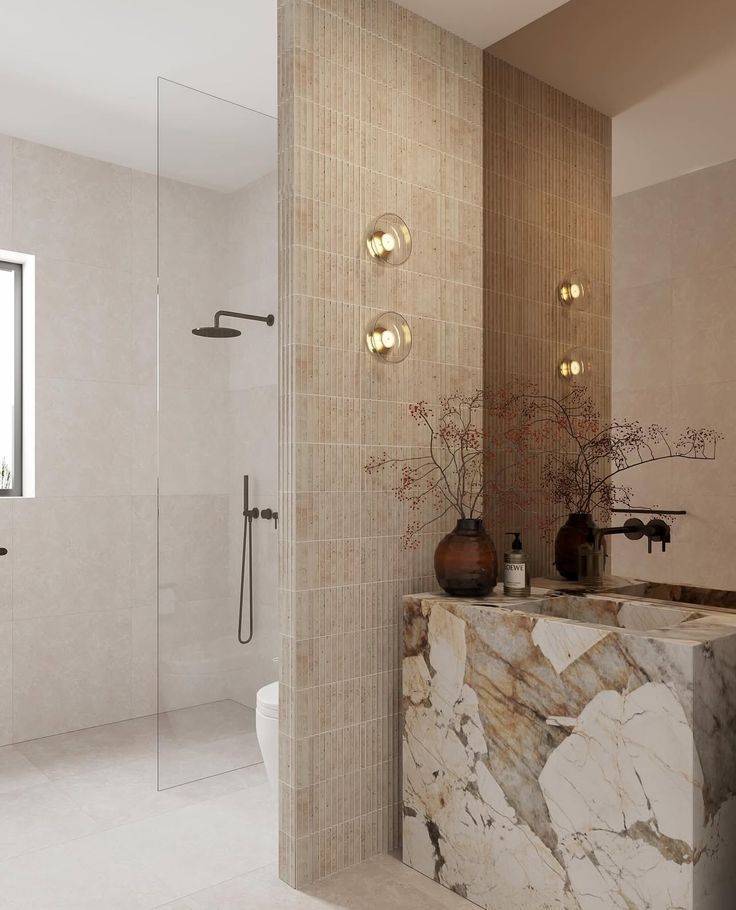 Modern bathroom with glass shower, beige tile walls, and a marble vanity — Hinch Plumbing In Breakwater, VIC
