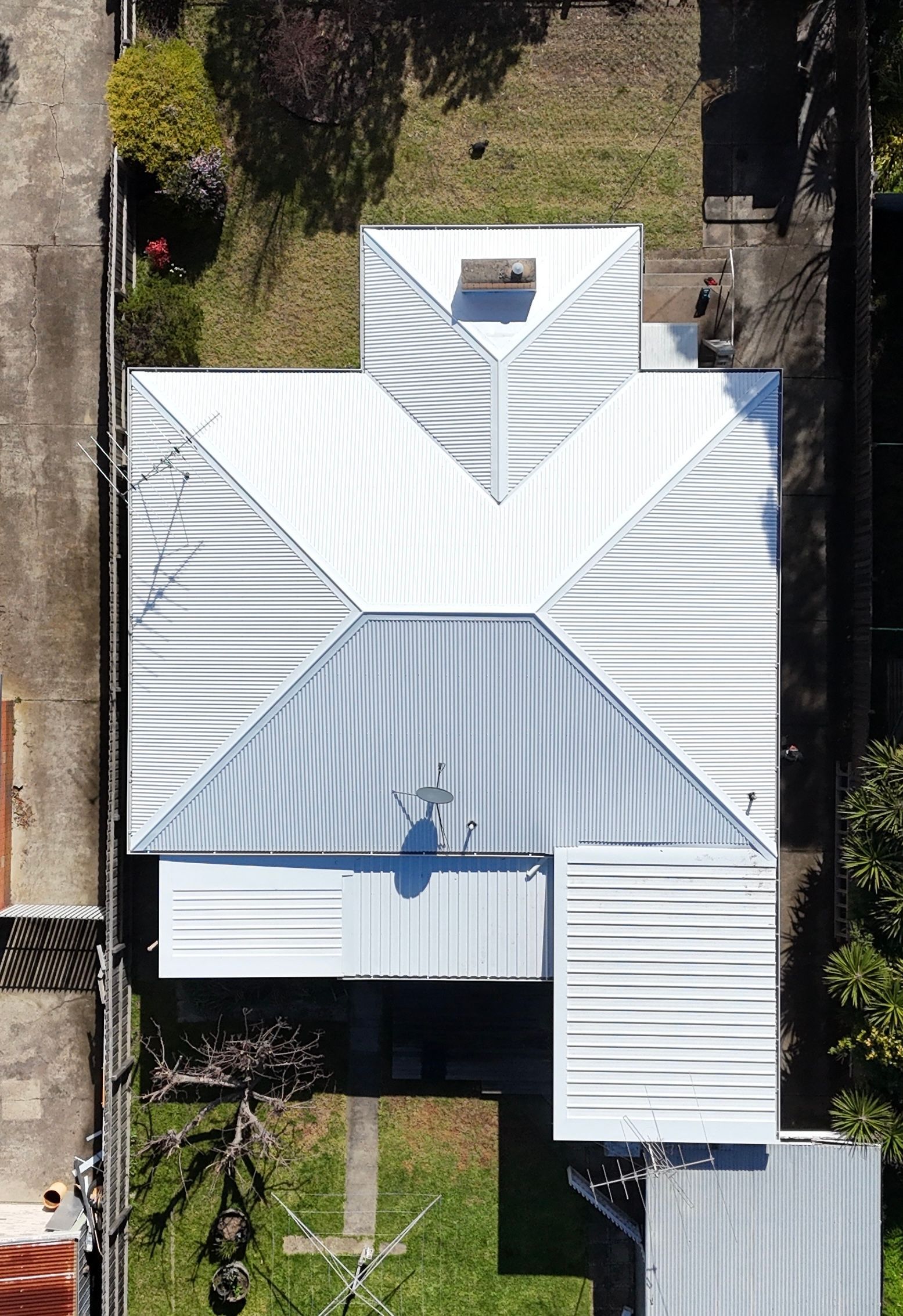 Aerial view of a white metal-roofed house with gray accents and a small front yard. — Hinch Plumbing In Breakwater, VIC