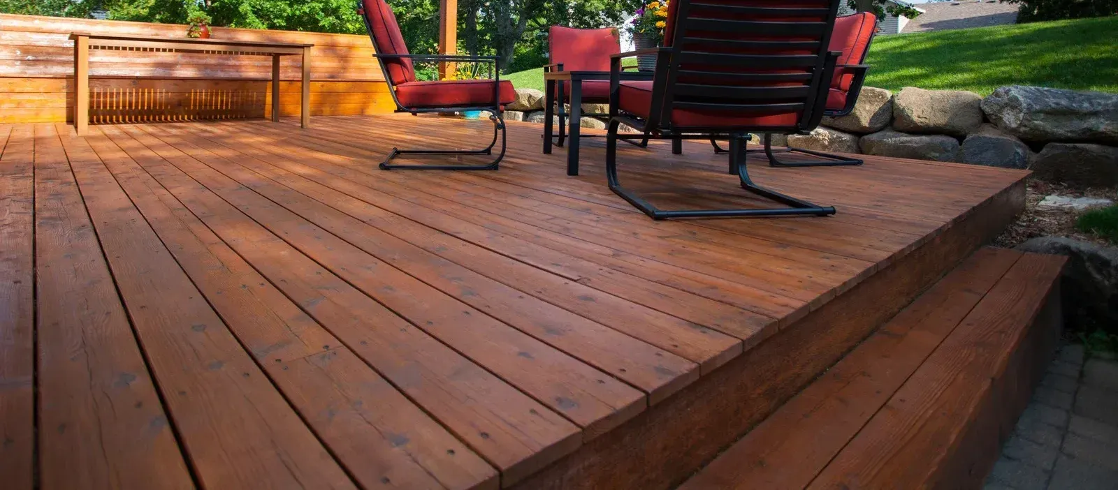 A wooden deck with a table and chairs on it.