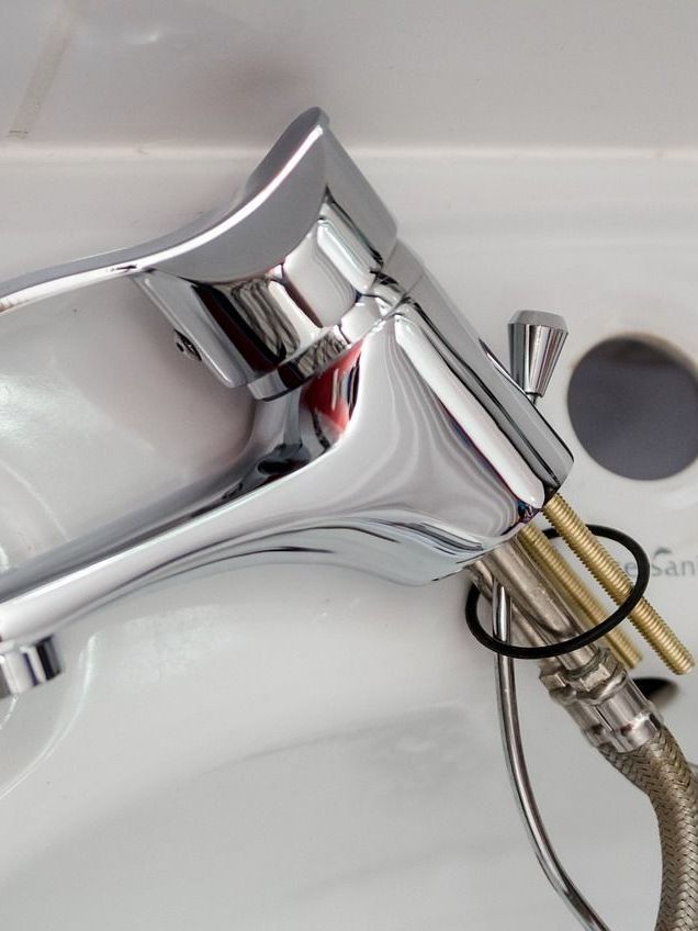 A close up of a shower head spraying water